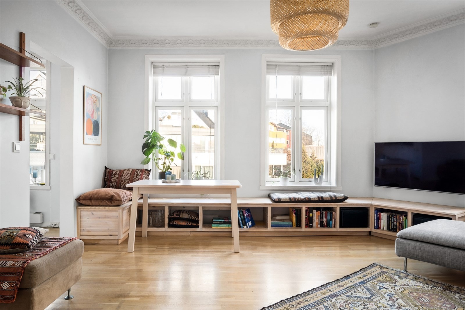 Store krysspostvinduer sørger for godt med naturlig lysinnslipp. Lekre klassiske detaljer som stukkatur og rosett i himling Galleribilde