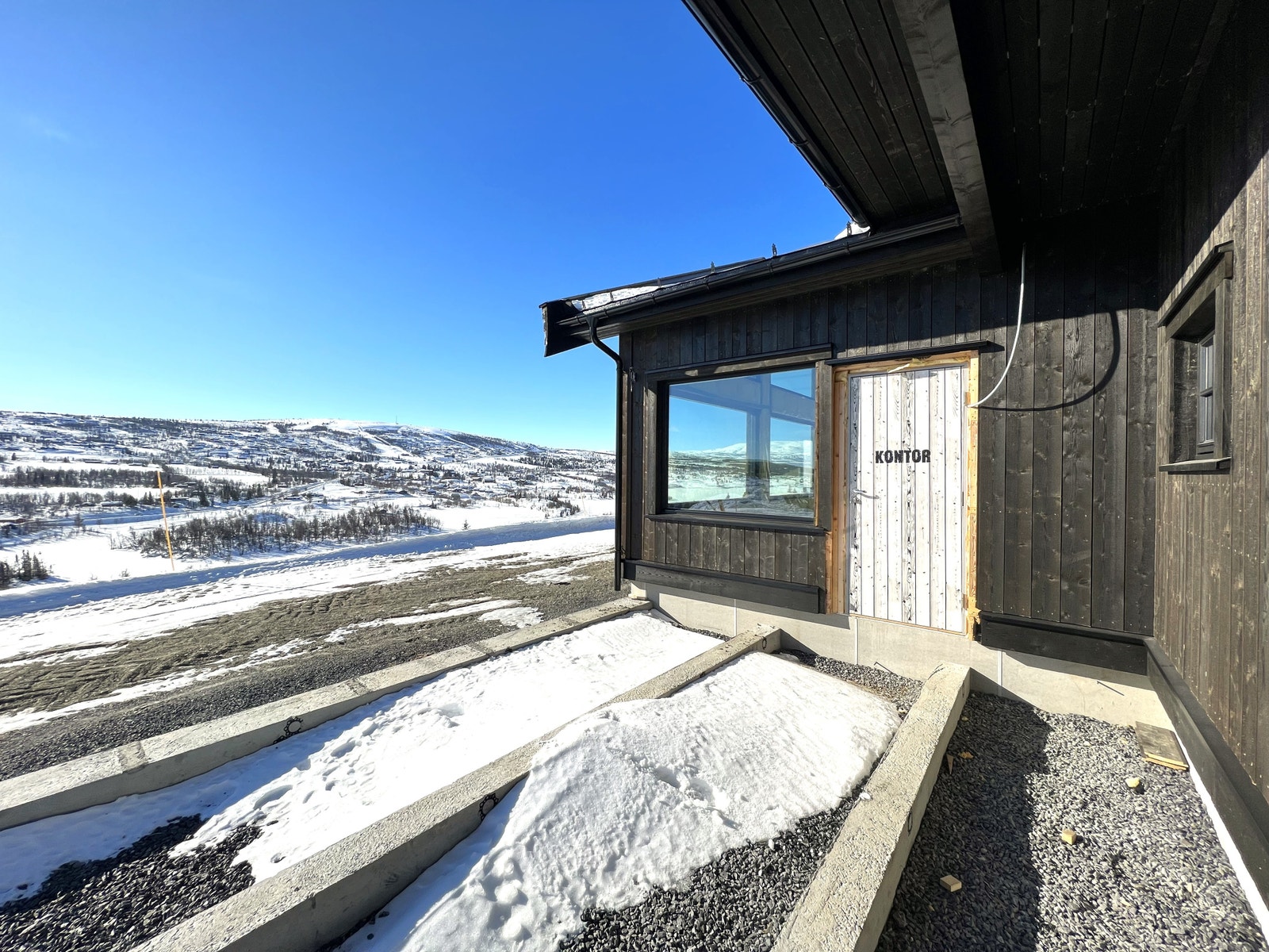 Hytta har en L-form, med delvis overbygd terrasse, som er i ly for vinden fra nord/vest. Galleribilde