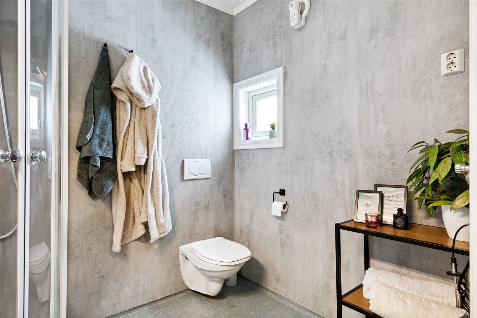 Toalettet er vegghengt og dusjkabinettet har regnfallsdusj, samt hånddusj. Galleribilde