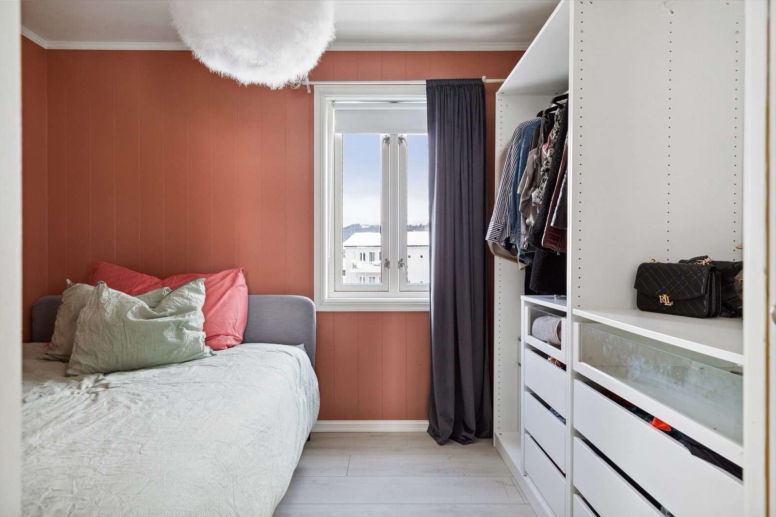 Langs den ene veggen er det åpen garderobeløsning med skuffer, hyller og heng. Galleribilde