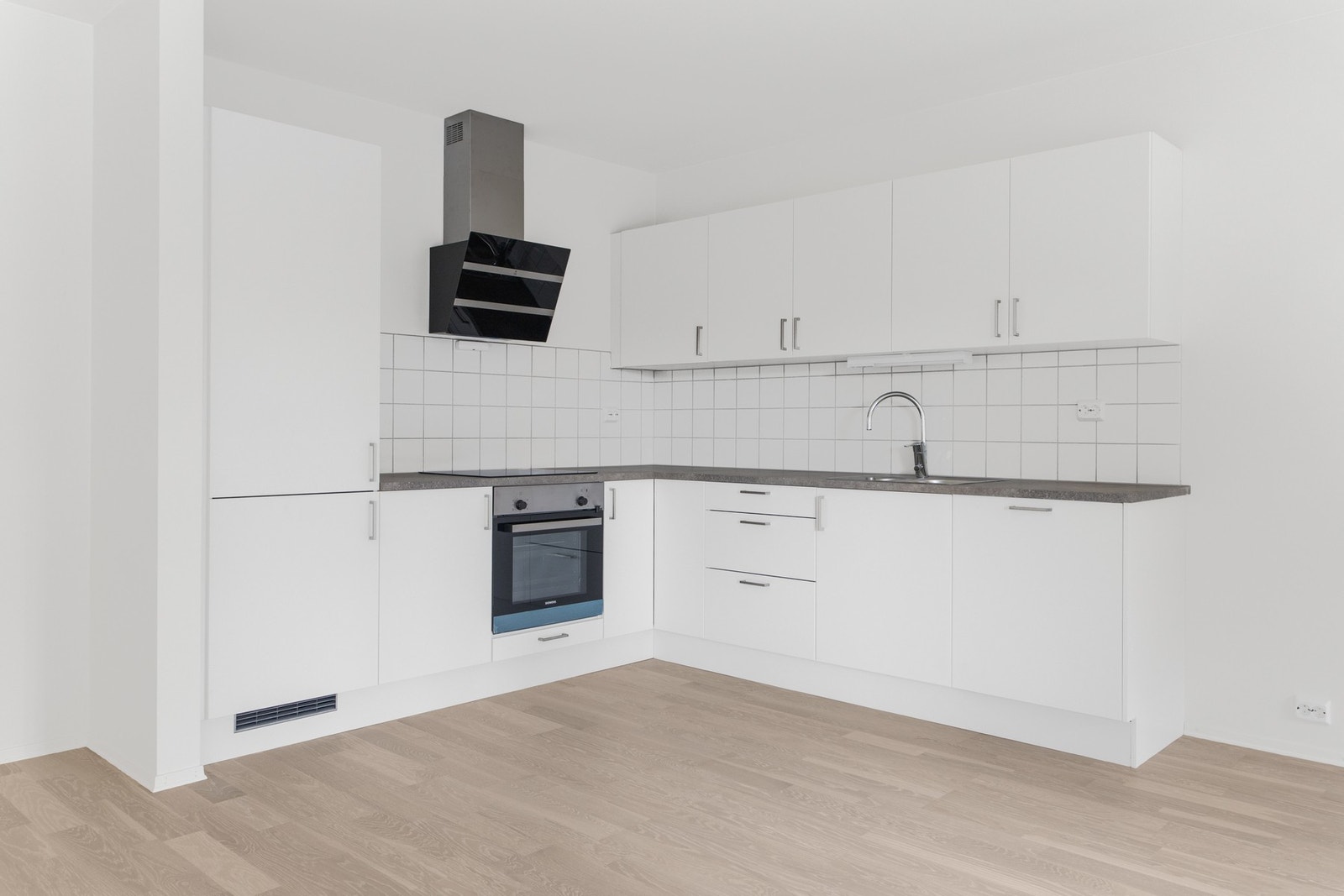 Hvit innredning fra Sigdal med integrert platetopp, stekeovn, kjøleskap og oppvaskmaskin Galleribilde