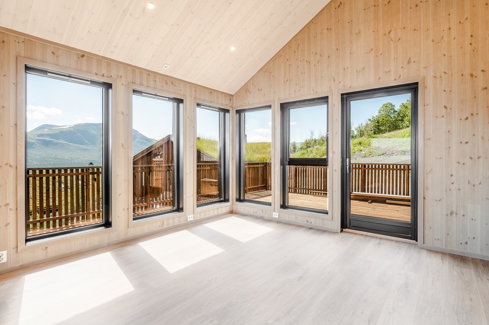 De store vinduene i front slipper inn rikelig med lys, noe som skaper en svært åpen og lys hytte. Galleribilde