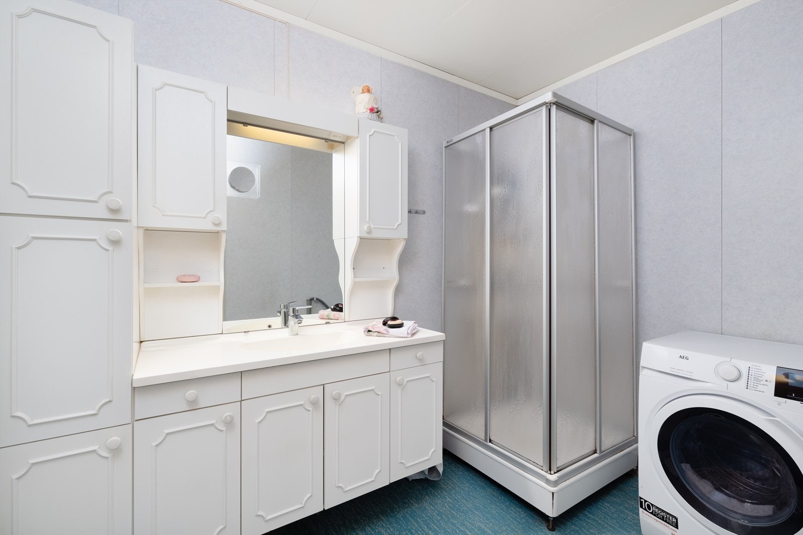 Badet er innredet med servant på innredning ogdusjkabinett. Opplegg for vaskemaskin. Galleribilde