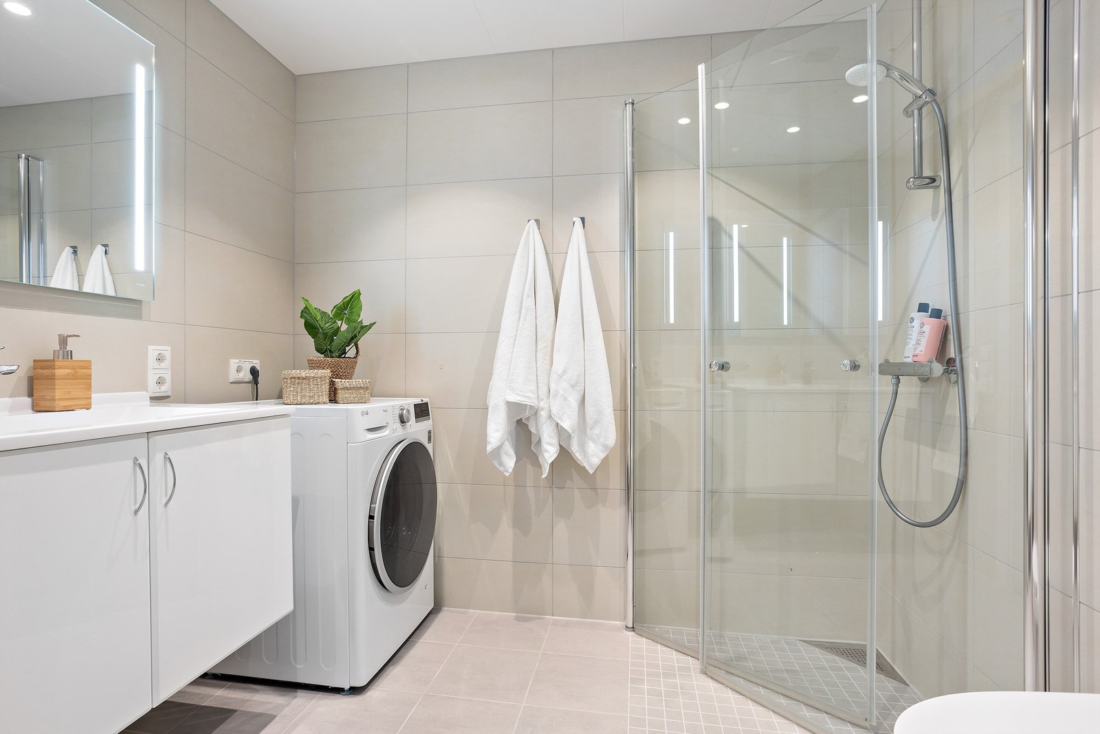 Badet har store, moderne farge- og materialvalg med varme i gulvet. Opplegg til vaskemaskin Galleribilde