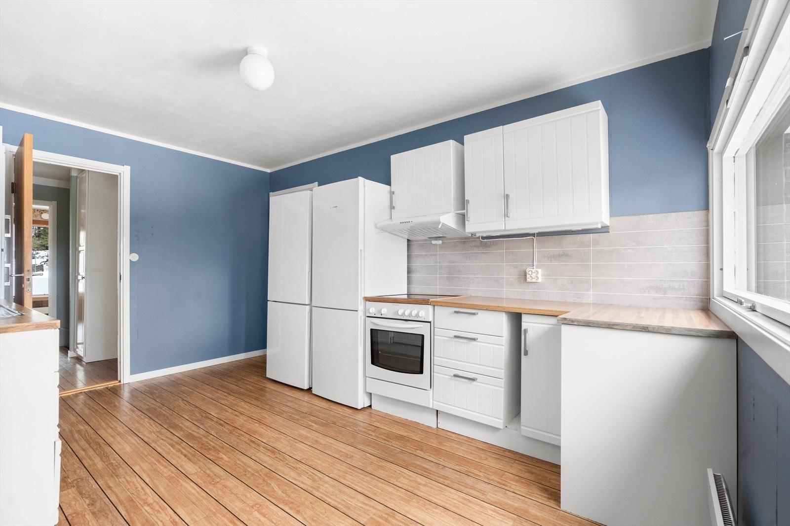 Kjøkkenet er malt i en koselig blåfarge som står godt til den hvite innredningen. Galleribilde