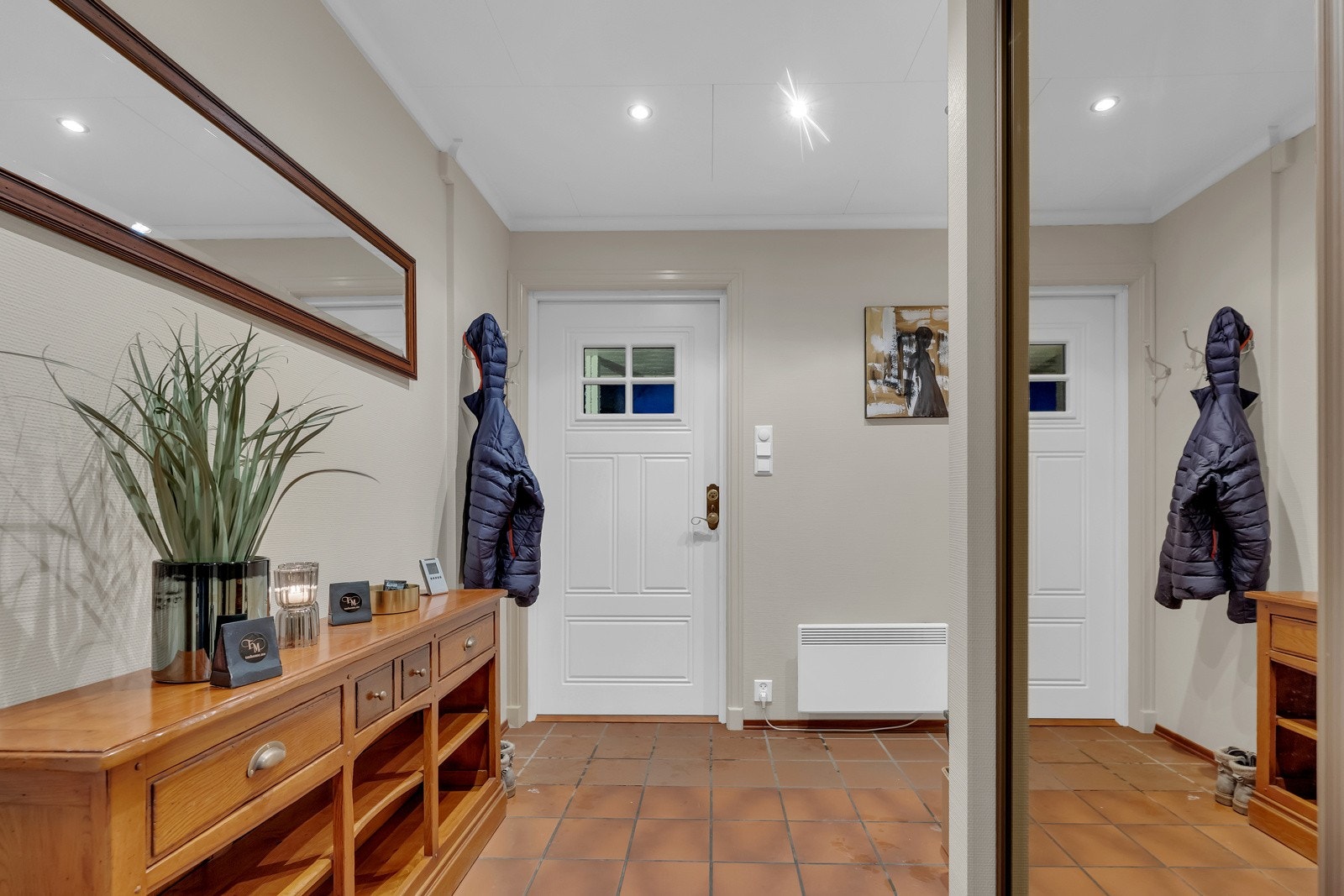 Entréen har en stor, flott skyvedørsgarderobe med speilfronter, hvor familien har god plass til å henge fra seg jakker og oppbevare sko. Den romslige størrelsen gjør at det enkelt kan innredes med annet ønskelig møblement etter behov. Galleribilde