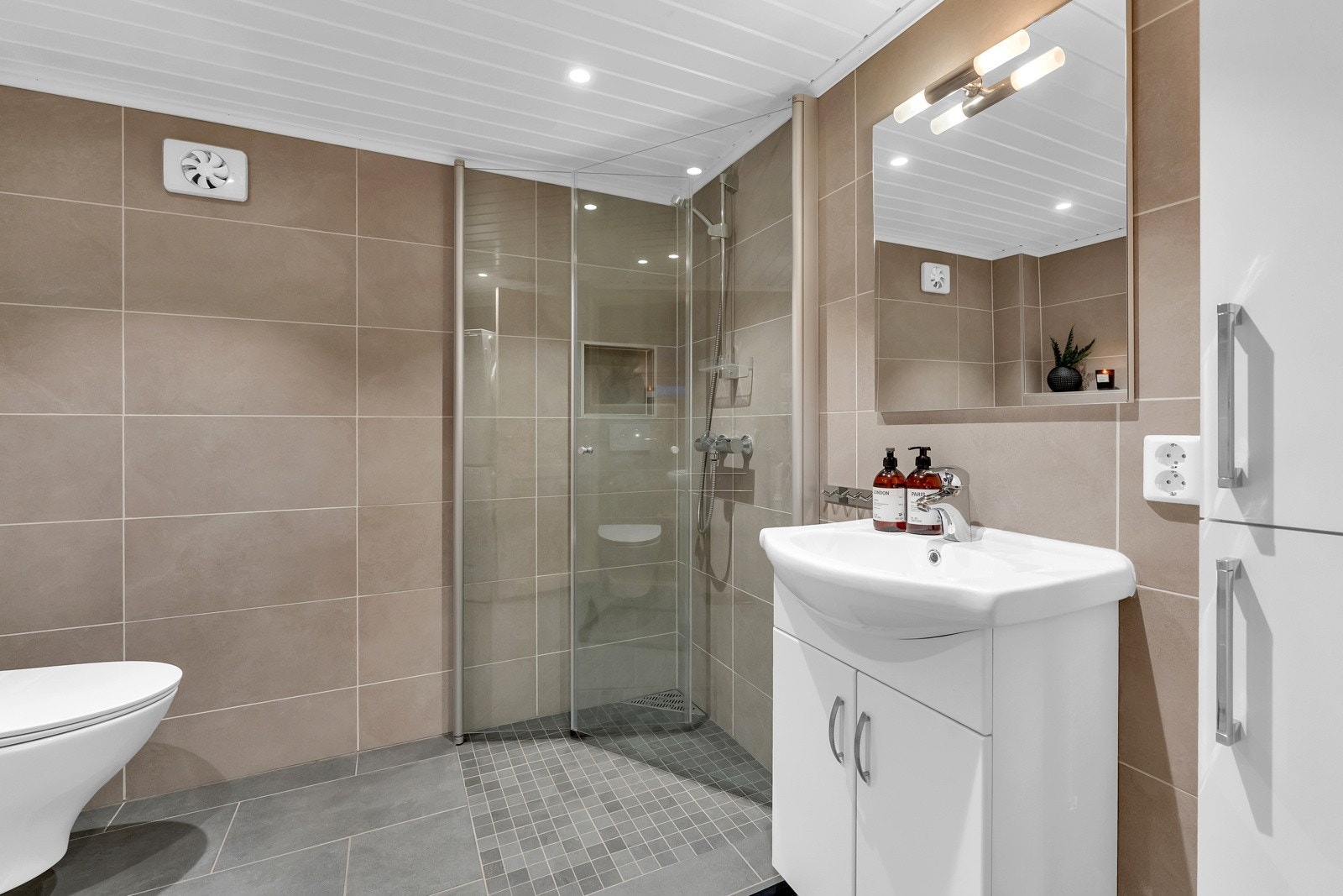 Badet har dusj med innfellbare dører, servant i helstøpt plate og veggfestet toalett. På badet i kjelleren er det opplegg for vaskemaskin. I gulvet er det lagt elektriske varmematter, slik som det også er gjort på badet i 1.etasje. Galleribilde