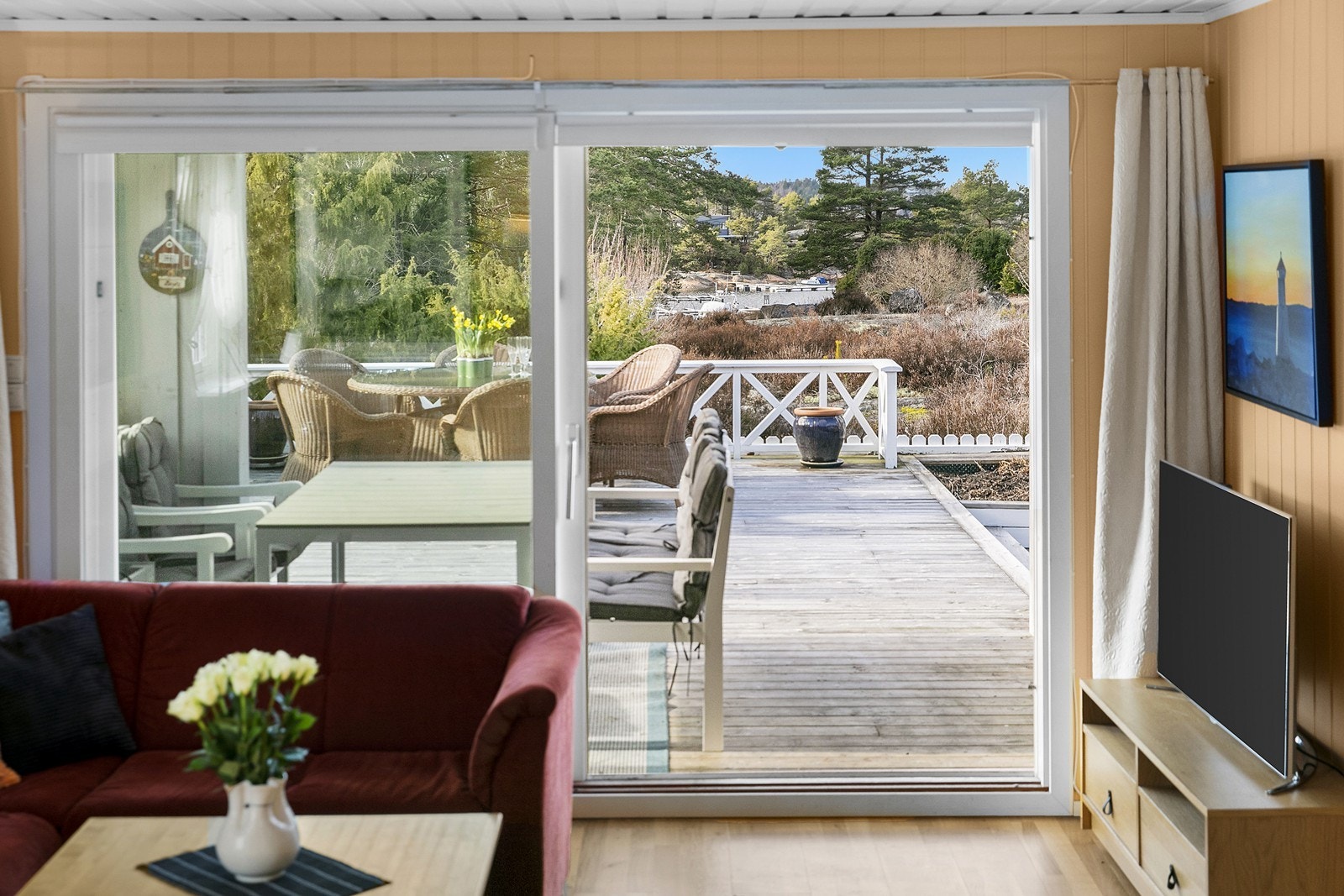 Stor skyvedør ut mot terrassen og godt med naturlig lysinnslipp. Utsikt til vannet fra stuen. Galleribilde