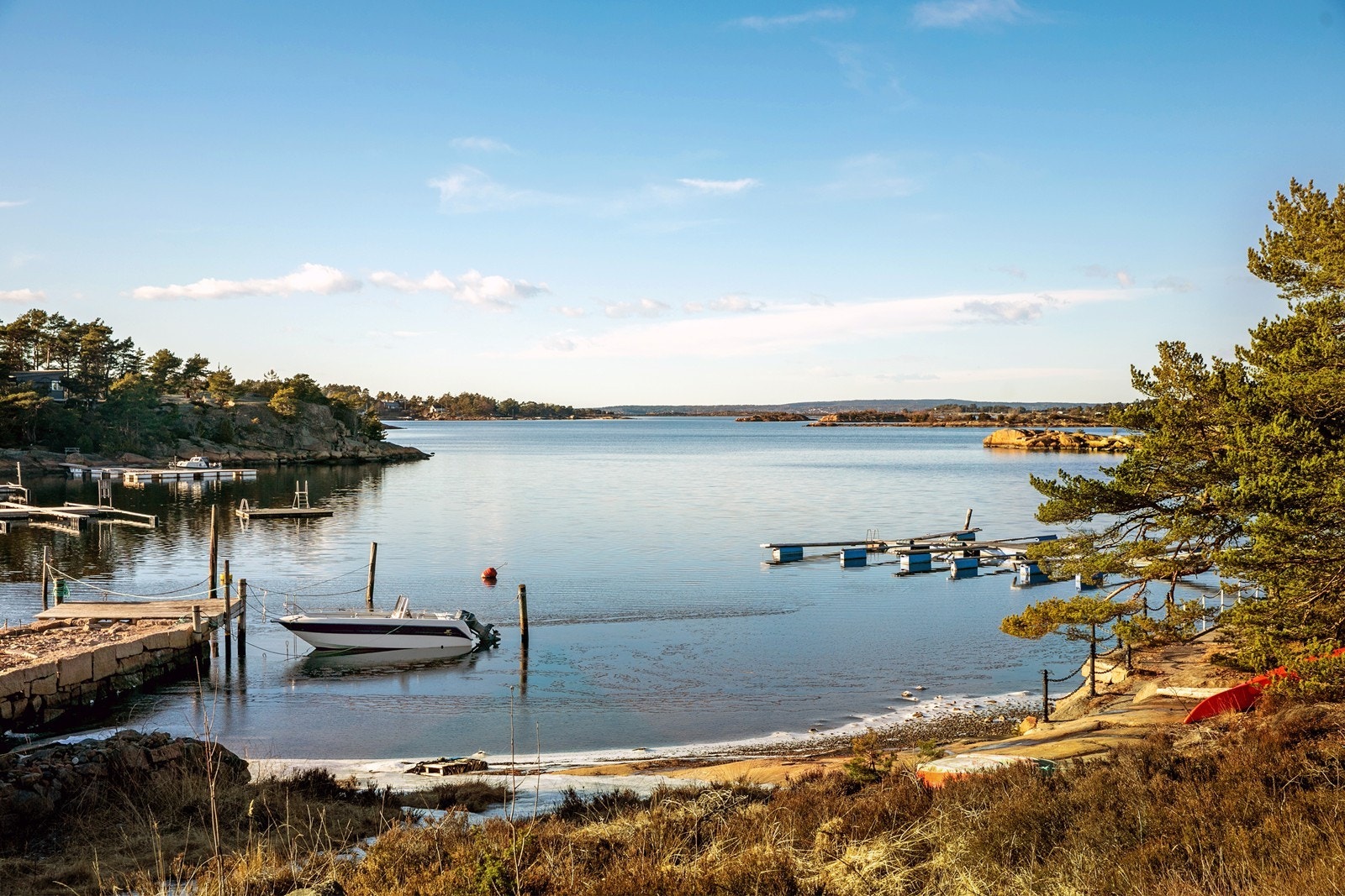 Fin sandstrand rett ved hytta. Bryggeområdet med båtplass ligger til høyre i bildet. I henhold til selger er det kun 11 høydemeter fra hytta og ned stranda. Galleribilde