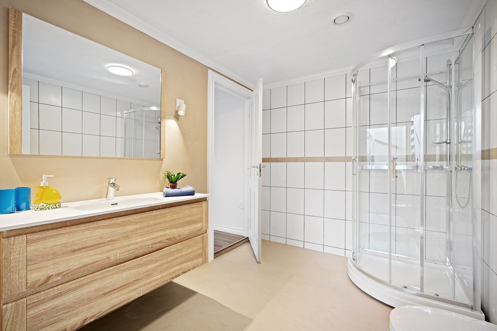 Fint bad i en suite løsning med soverom, men også tilkomst fra gang. Badet har moderne innredning, dusjkabinett, toalett, mikrosement på gulv og delvis fliser og våtromstapet på vegg. Galleribilde