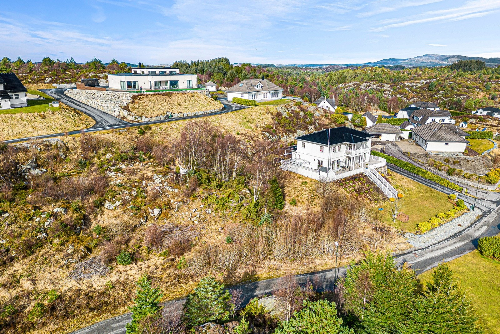 Skrånende naturtomt. Vannledninger ligger i veien like nedenfor. Galleribilde