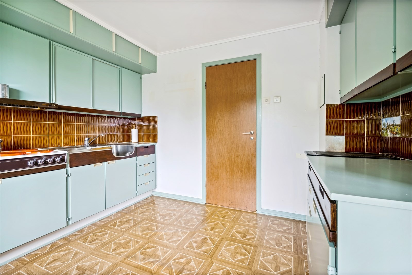 Kjøkkenet har malte slette fronter, skap og skyvedører - Godt med skap- og benkeplass Galleribilde