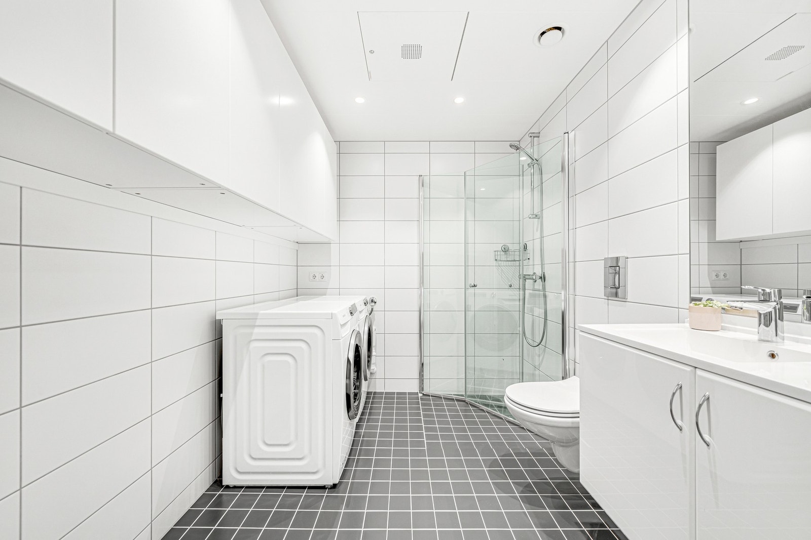 Flislagt bad på 5,3 kvm med varmekabler i gulv og med ekstra lagringsplass i overskap på vegg Galleribilde