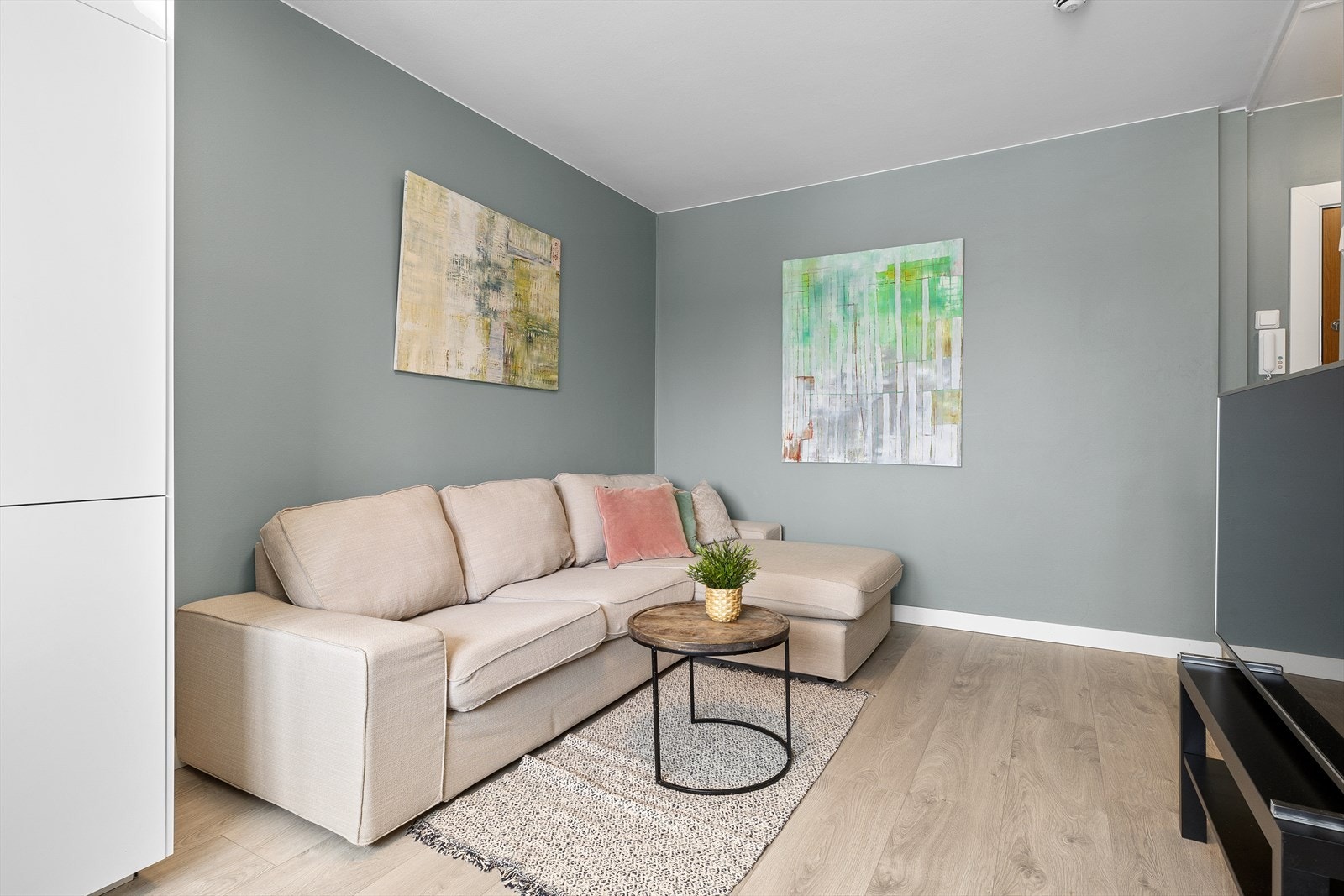 Innred med sofa, bord og tilhørende mediebenk. Galleribilde