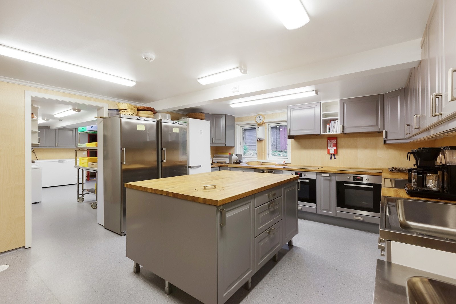 Storkjøkkenet er inndelt med eget grovkjøkken/vaskerom som er til høyre i bildet. Der er det innredet med industrioppvaskemaskin, utslagsvask, oppvaskbenker og skap for oppbevaring. Det følger også med 4 frysere. Galleribilde