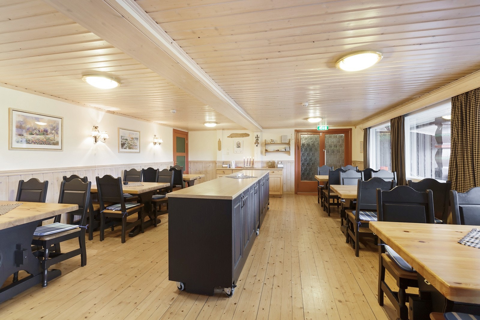 Midt i rommet er det en kjøkkenøy for å kunne sette ut mat og ha all dekketøy i skapene under Galleribilde