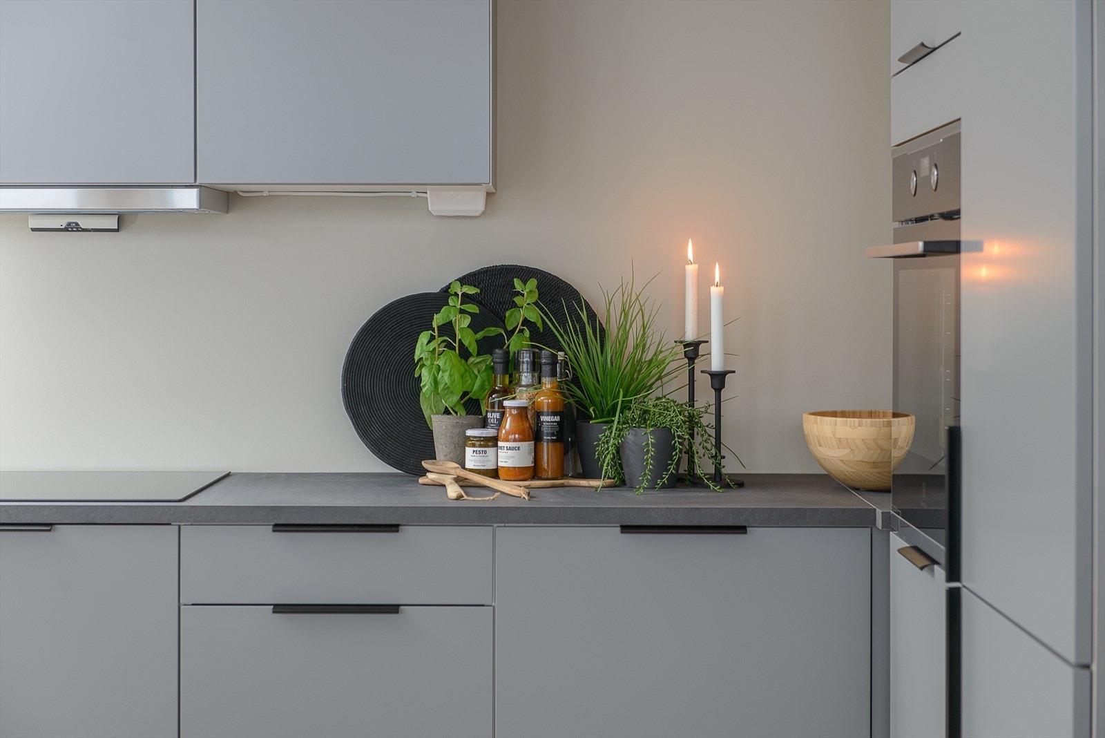 Tidsriktig fargevalg på kjøkkeninnredningen fra HTH som er i grå utførelse med sorte detaljer, sort benkeplate og integrerte hvitevarer. Bildet viser riktig standard på leveransen. Galleribilde