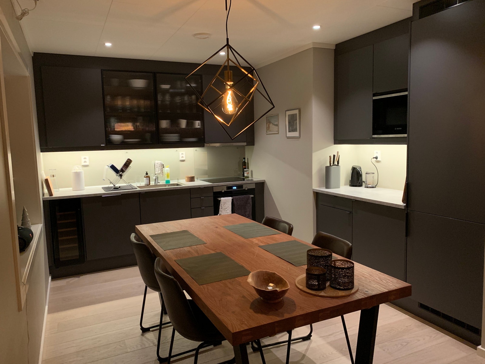 Kjøkken med indjuksjonskomfyr, oppvaskmaskin, vinskap, kjøleskap/frys og micro Galleribilde