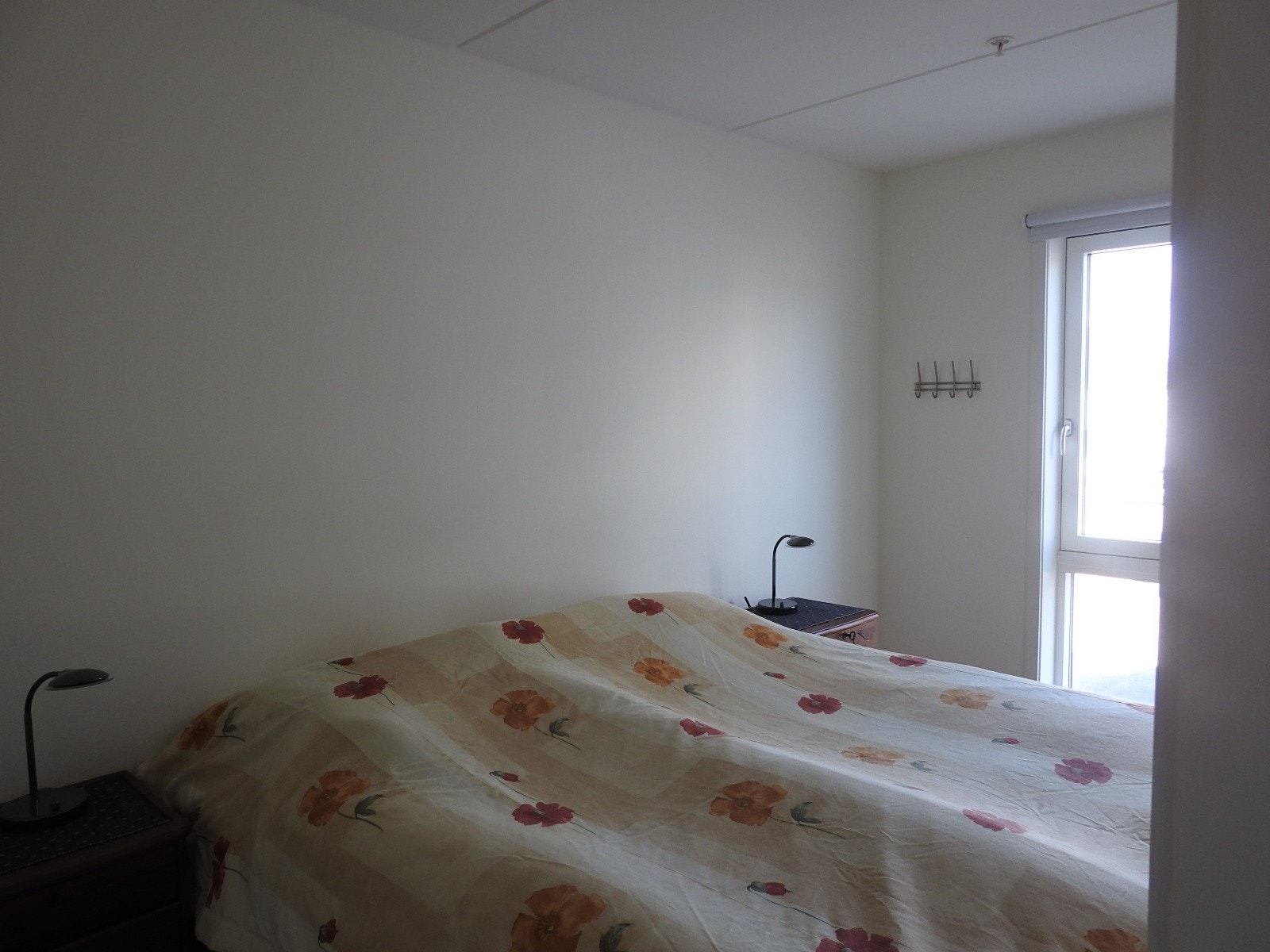 Romselig soverom med dør inn på hver side av dobbelt seng Galleribilde