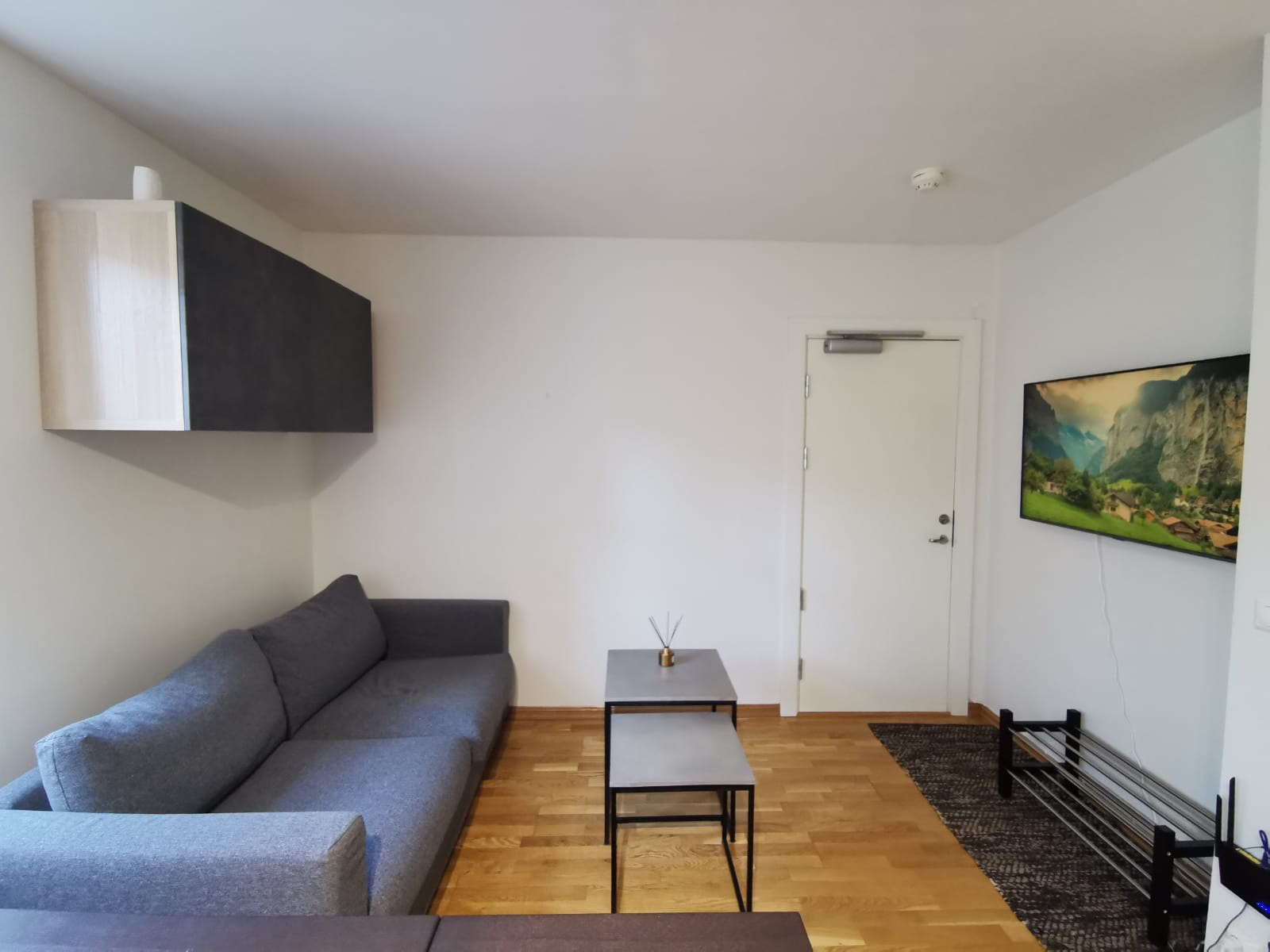 Sovesofa med uttrekkbar sengeløsning. Sengetøy + dyner har vært oppbevart i skap over sofa. Galleribilde