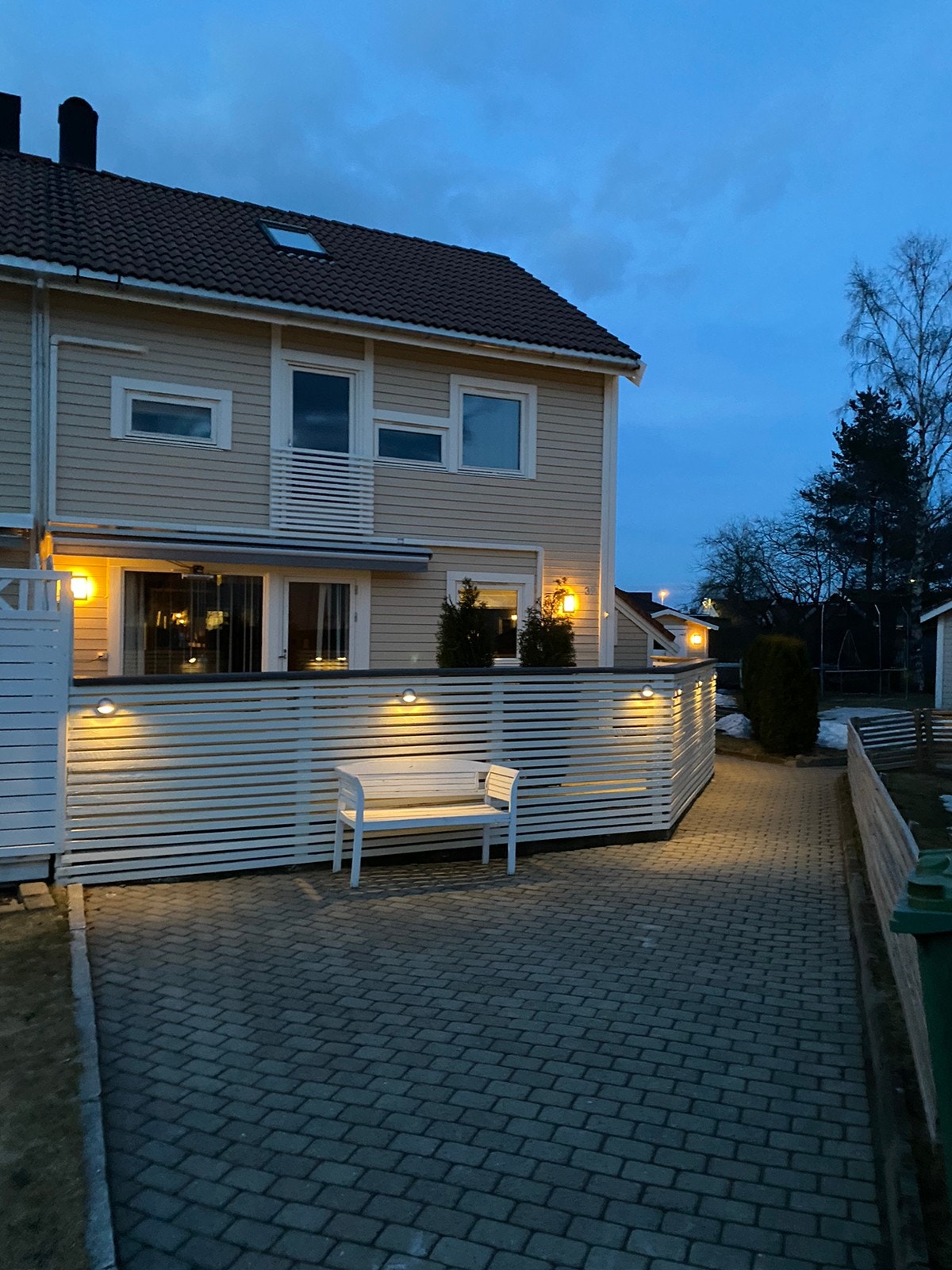 Fasade mot tunet med lekeplass, lyssatt rekkverk rundt terrassen,3etasjer Galleribilde