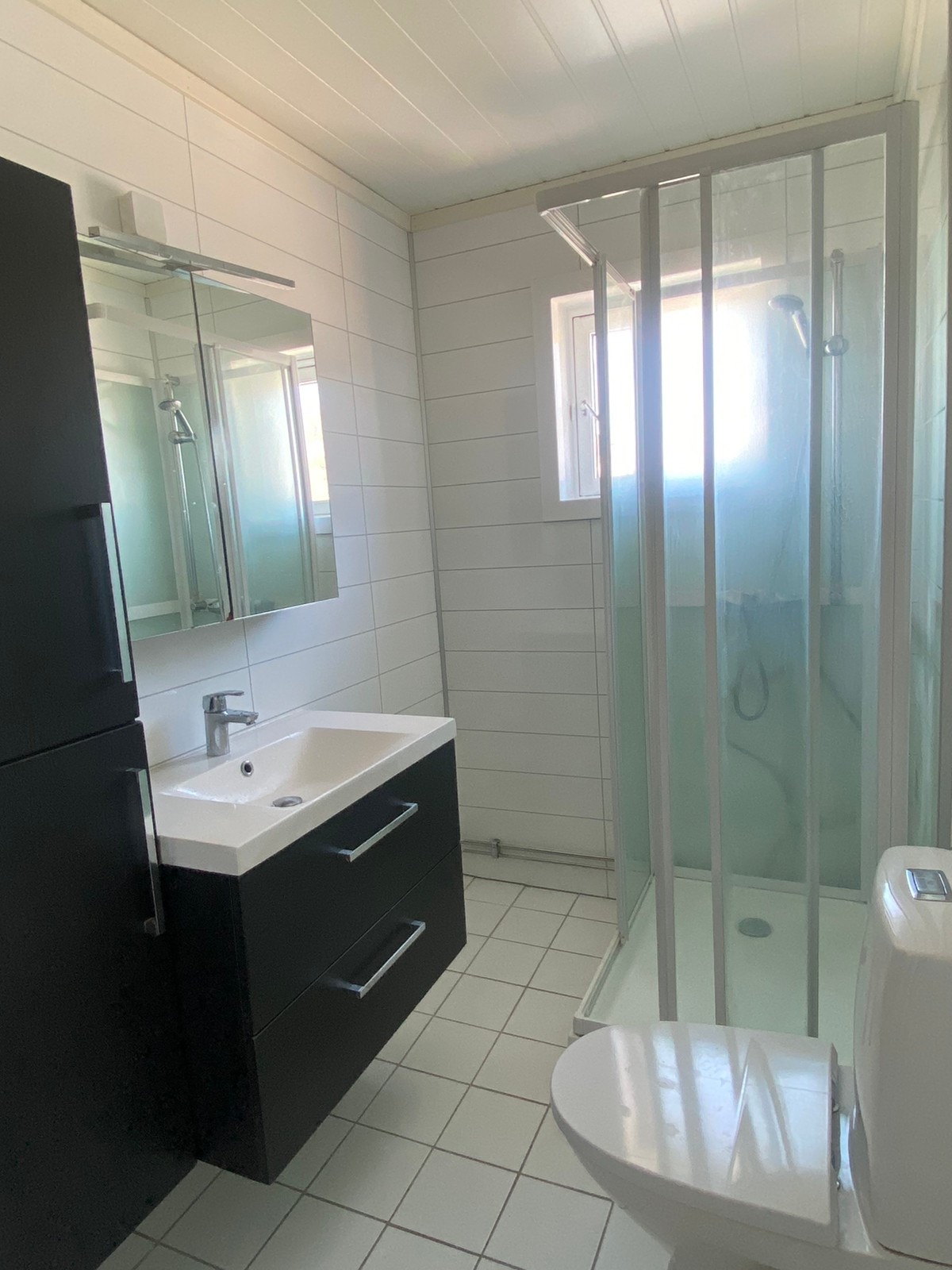 Bad i hvite flismønstrede baderomsplater, hvite gulvfliser og gulvvarme Galleribilde