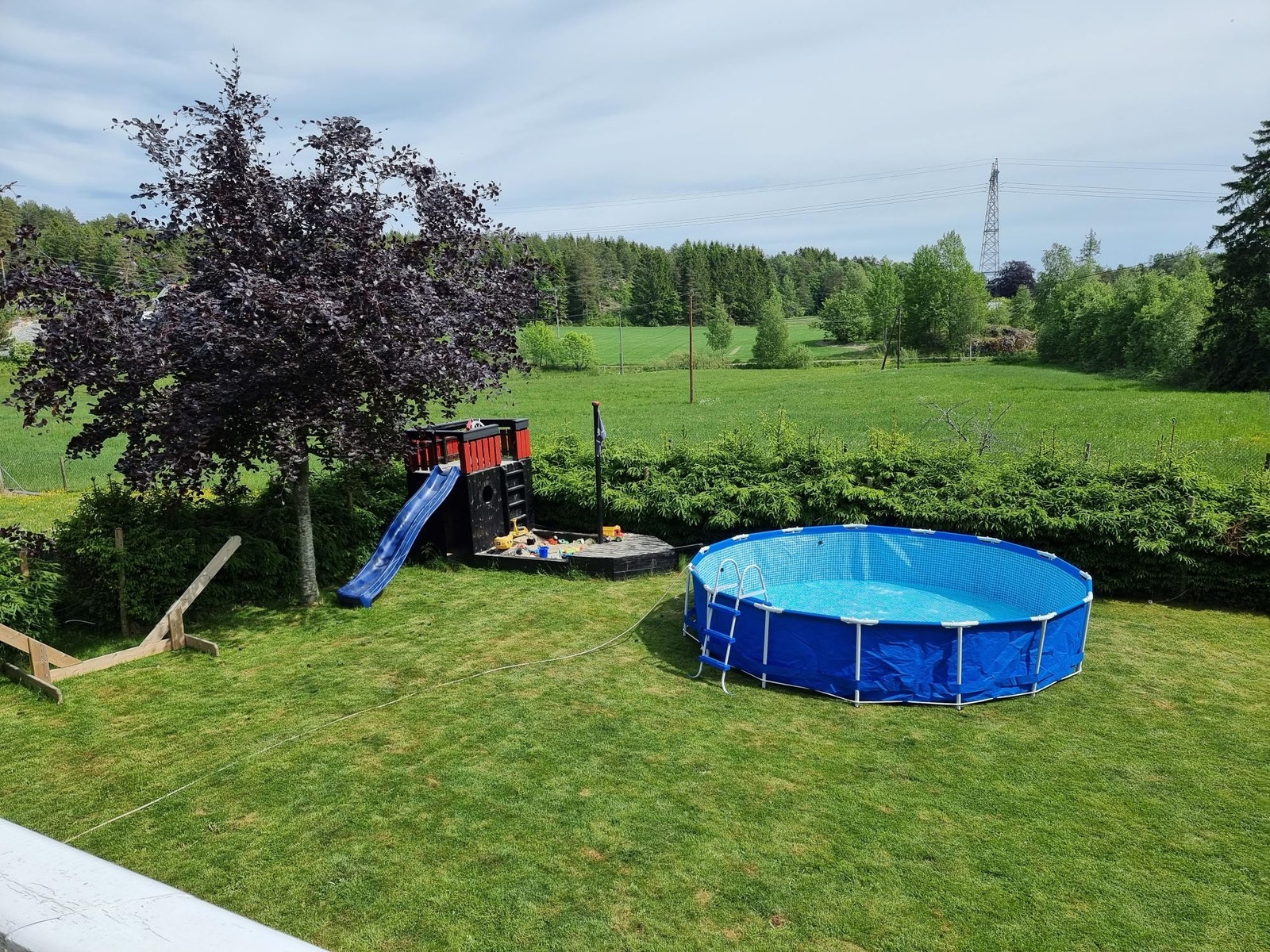 Stor inngjerdet hage med lekestativ, sandkasse, hengekøye og trampoline. Disponibelt badebasseng Galleribilde