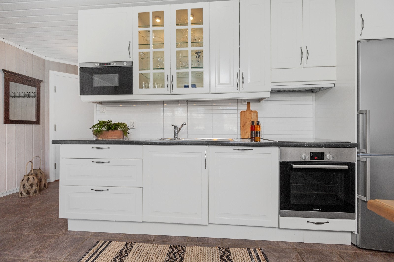 Kjøkkenet har integrert komfyr, steketopp og oppvaskmaskin, samt frittstående kjøleskap Galleribilde