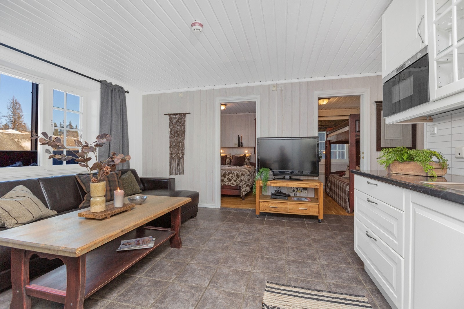 Store vindusflater gir hele oppholdsrommet godt med naturlig lys Galleribilde