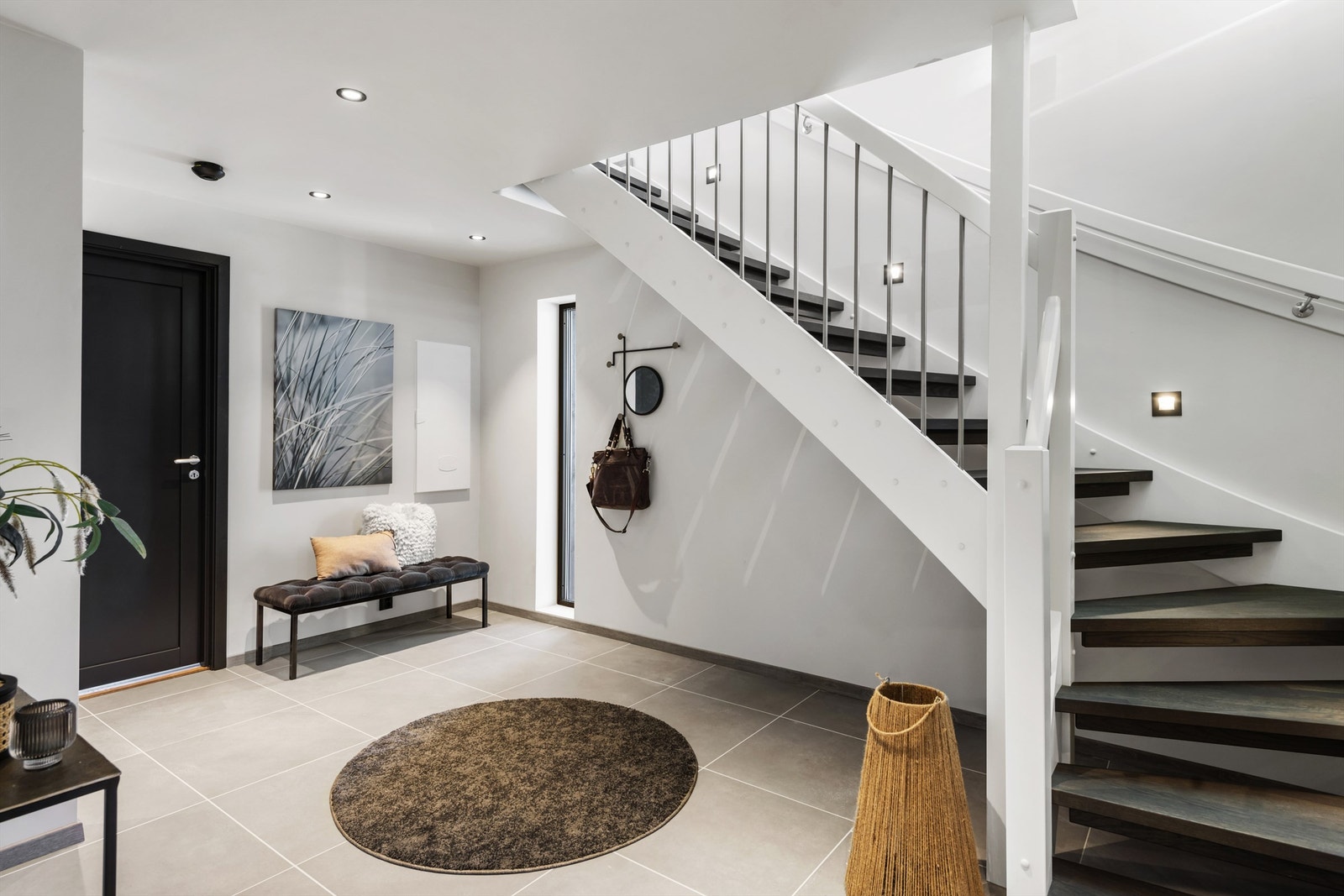 Lyst og pent med store, flotte fliser på gulv, malte veggflater og malte takflater med downlights Galleribilde