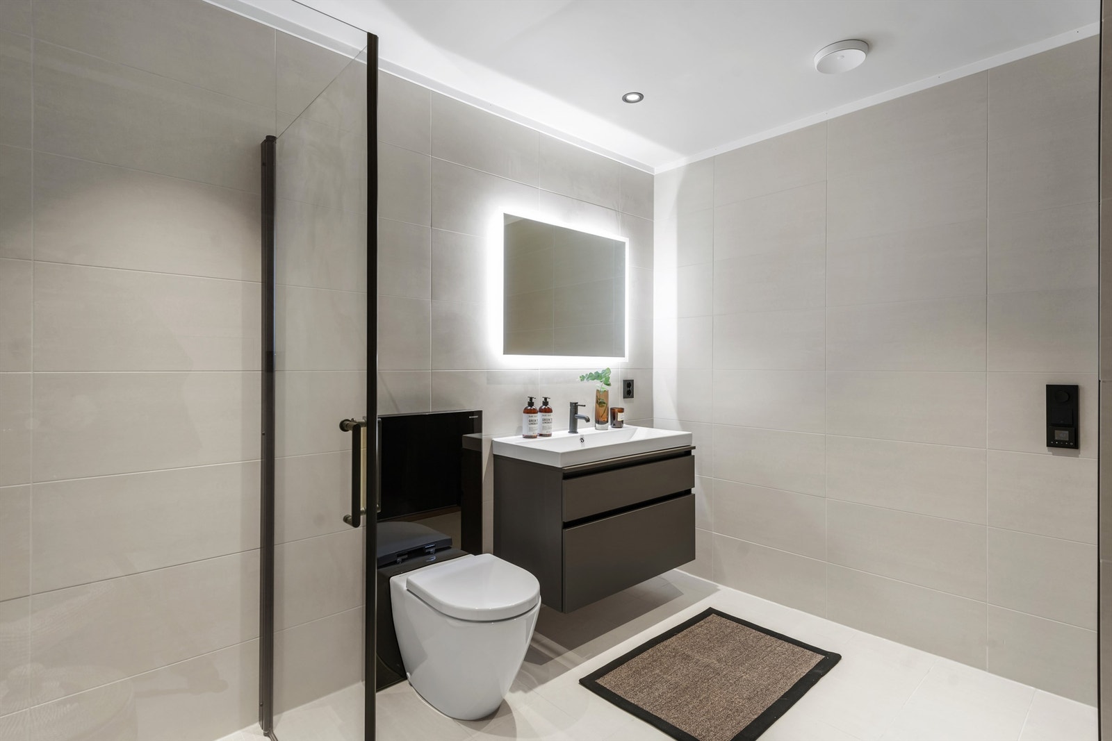 Badet er innredet med toalett, dusjhjørne og baderomsinnredning med servant og skuffer Galleribilde