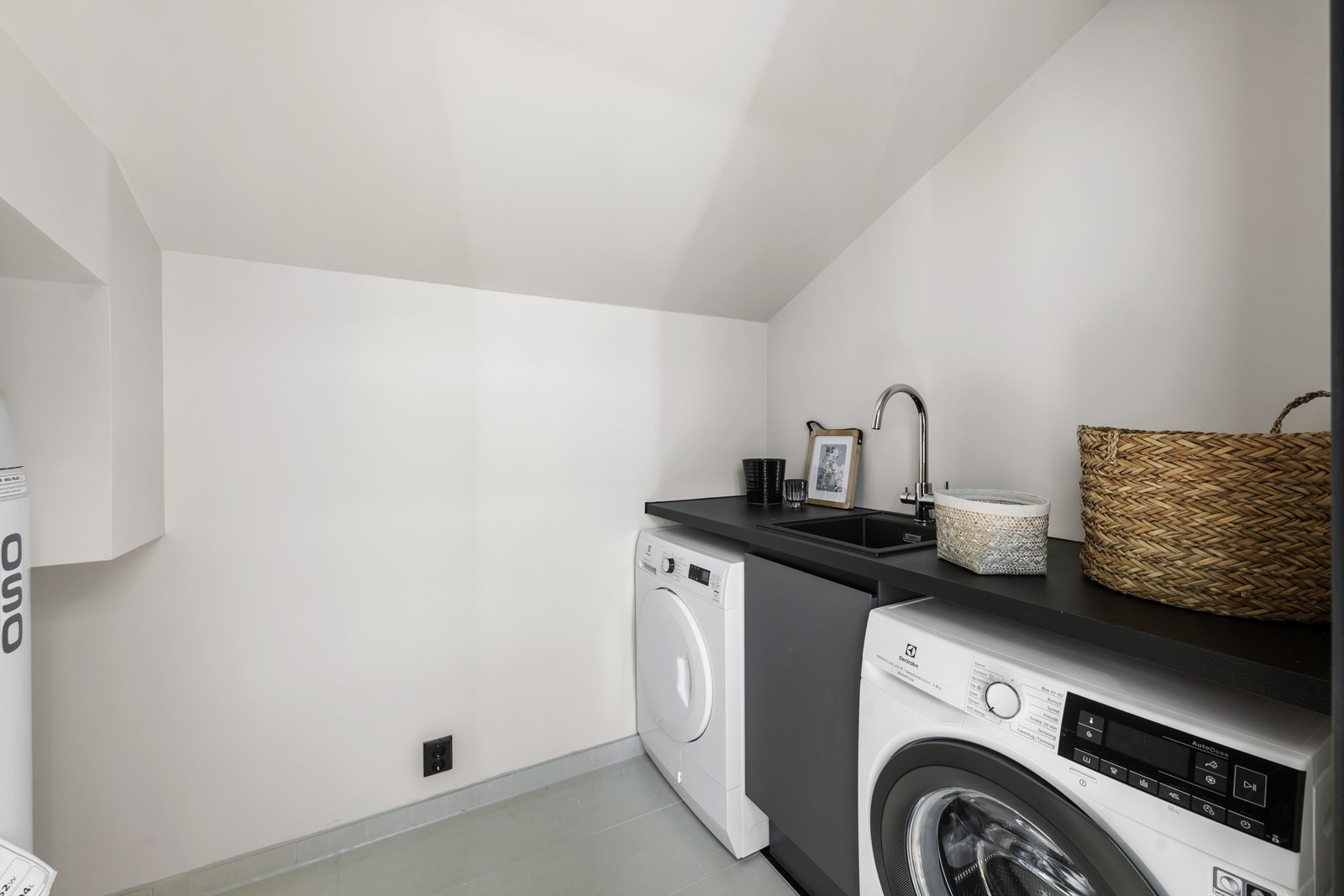 Praktisk vaskerom/teknisk rom innredet med vegghengt utslagsvask, Nordanro innredning, vaskemaskin og tørketrommel. Galleribilde