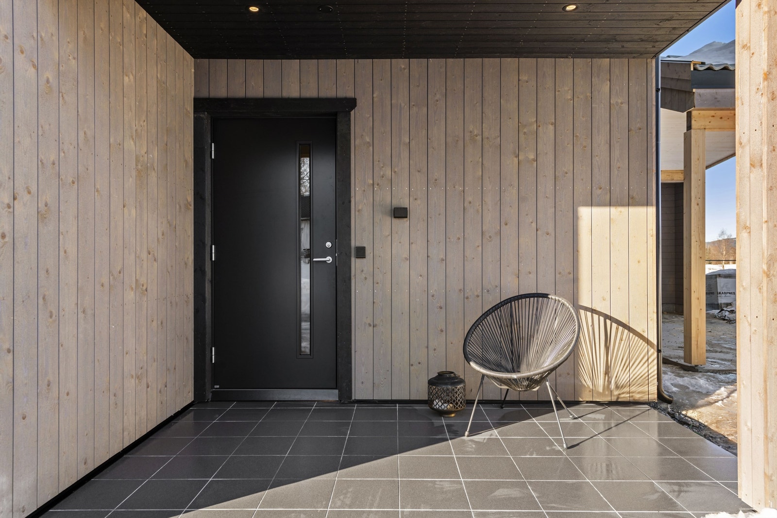 Innbydende inngangsparti med overbygg og plass for liten sittegruppe Galleribilde