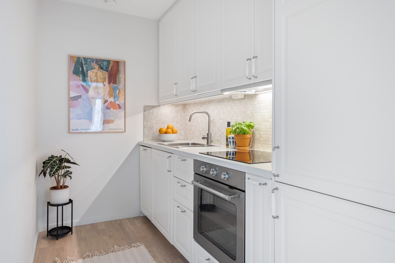 Lys kjøkkeninnredning fra Ikea med profilerte fronter, fliser på vegg over benkeplaten og laminat benkeplate Galleribilde