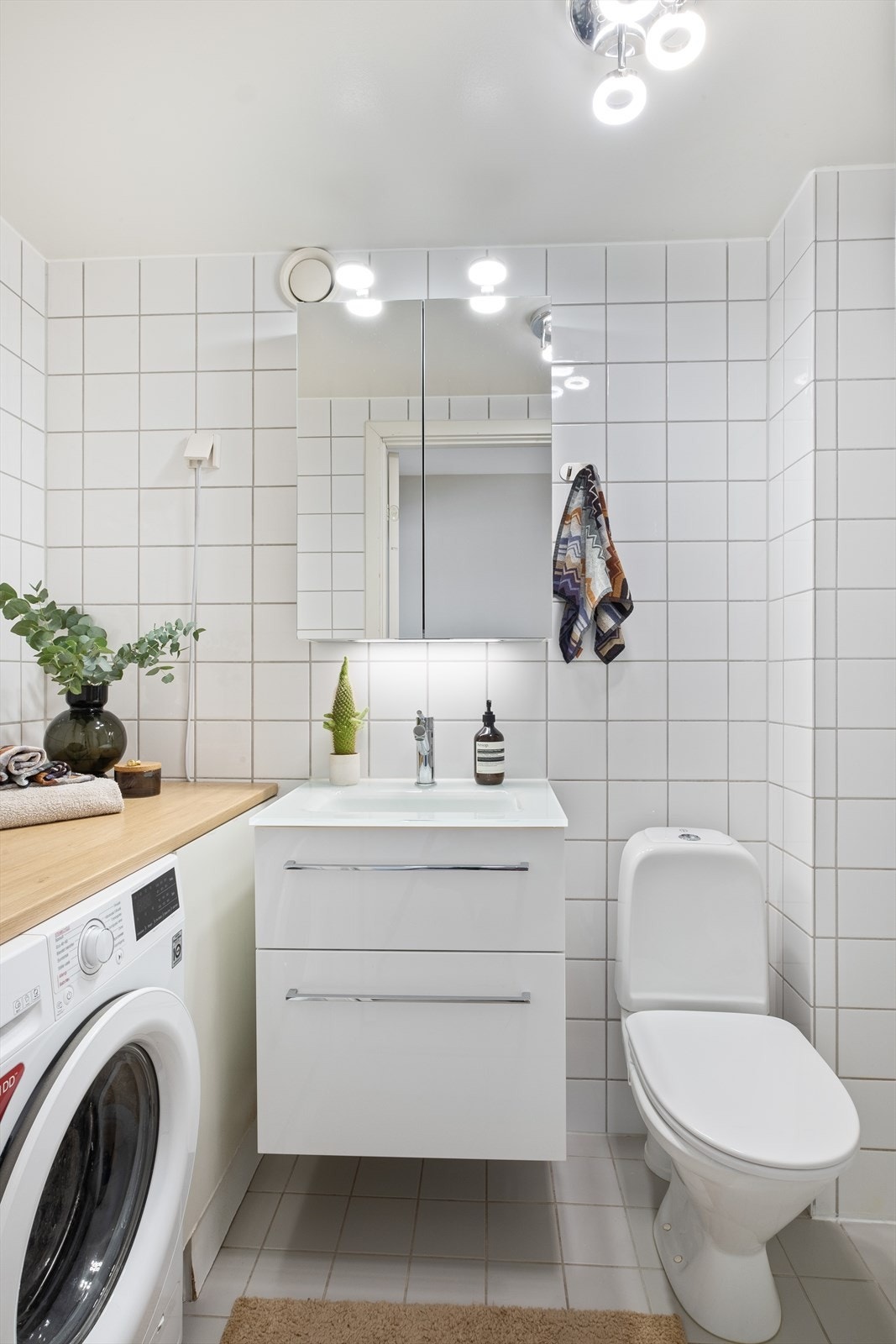 Pent baderom fra 2002 med flislagte overflater, gulvvarme og opplegg for vaskemaskin Galleribilde