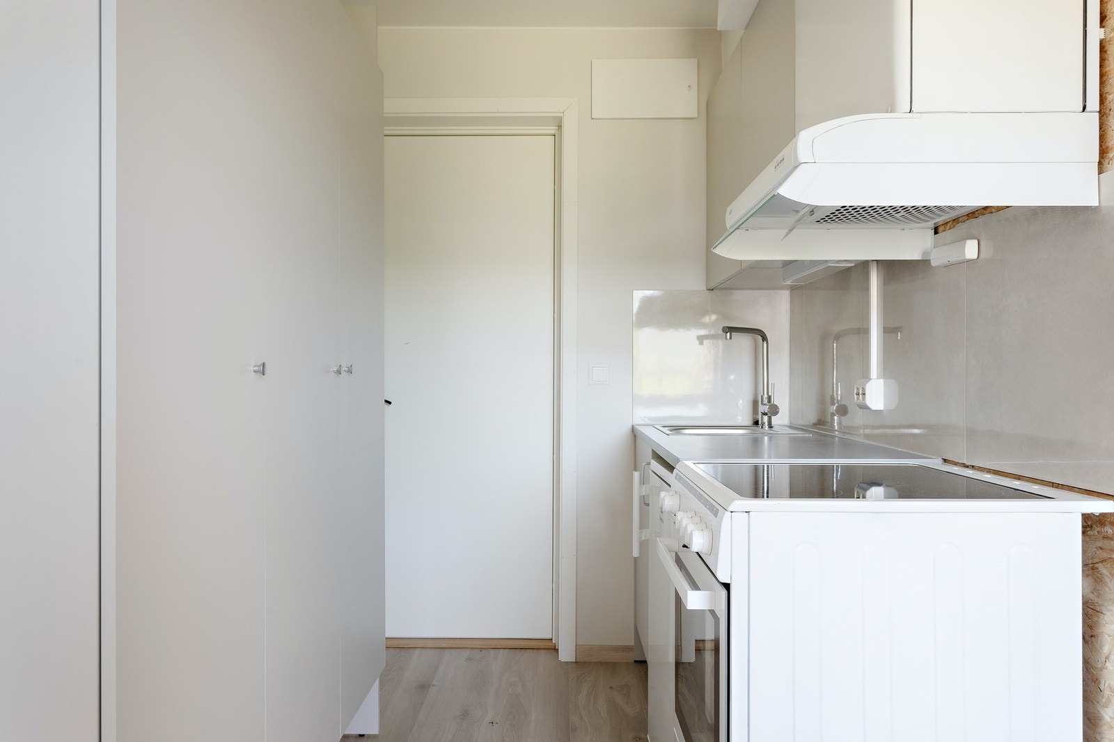 Kjøkkenkrok med komfyr, koketopp og kombinert kjøleskap og fryser, samt god oppbevaringsplass. Galleribilde