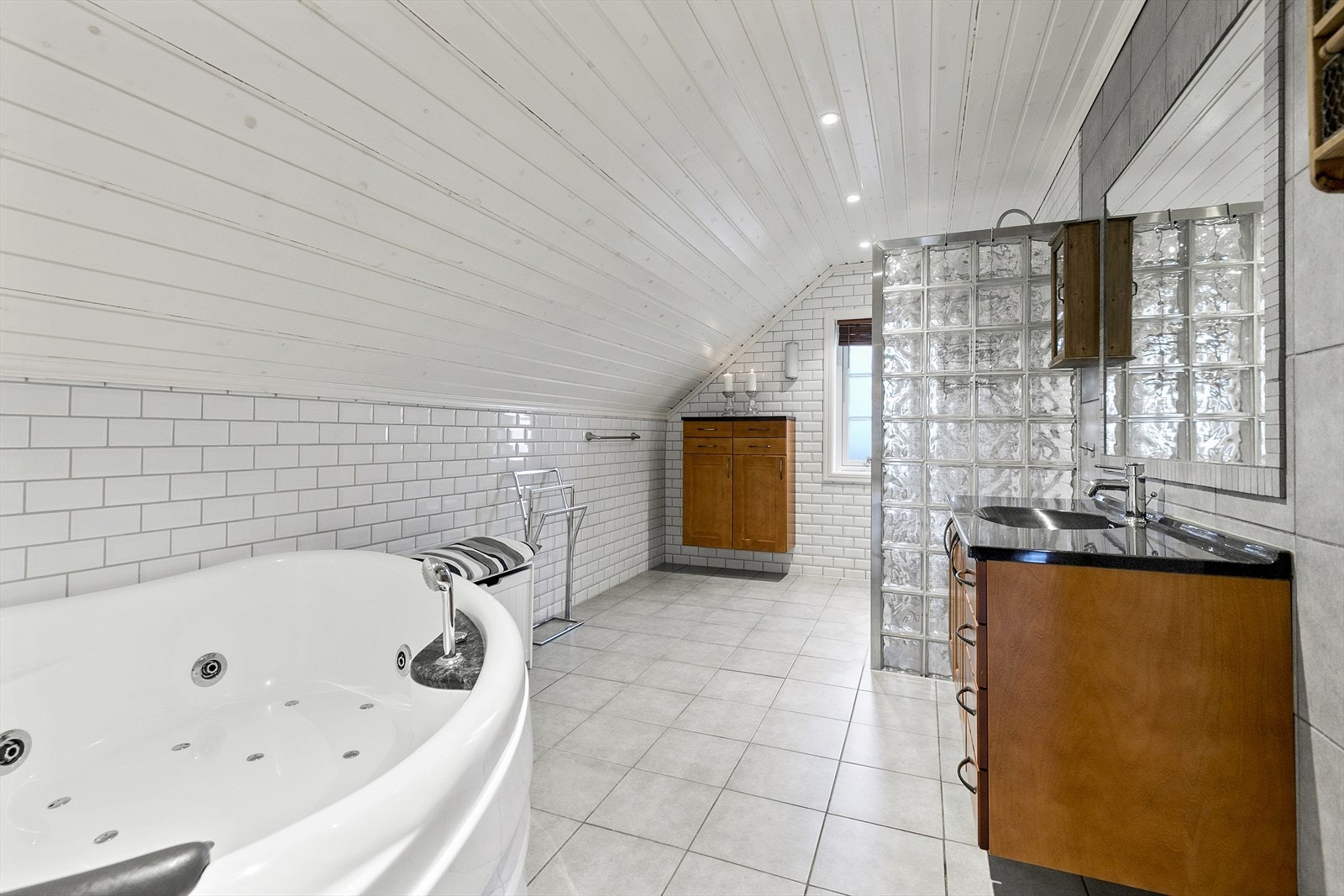 Romslig og lekkert bad med delikate fliser og downlights i himling. Badet har dusjnisje og boblebad Galleribilde