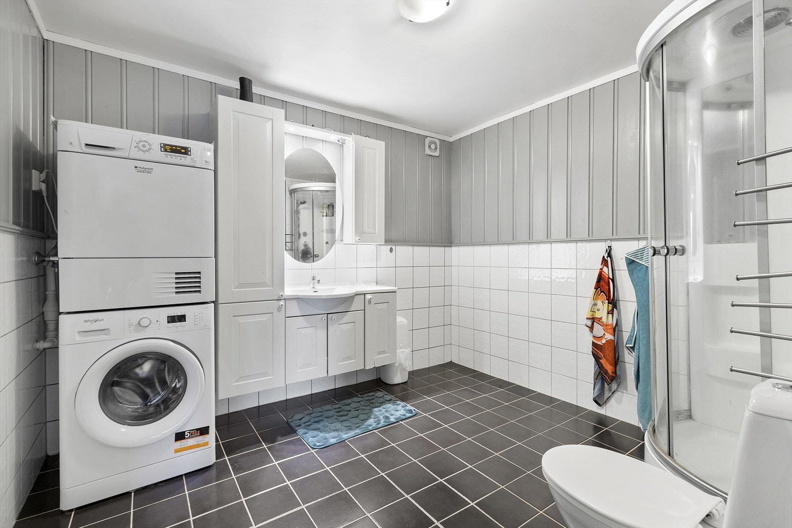 Bad er innredet med dusjkabinett, servantskap, wc og opplegg for vaskemaskin og tørketrommel Galleribilde
