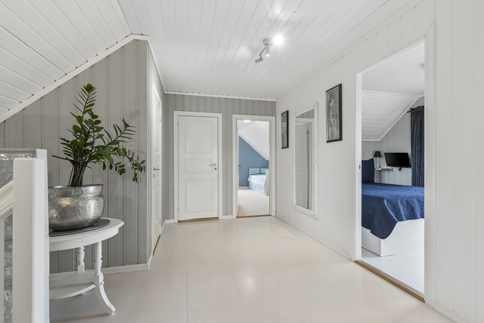 Lys og åpen gang med tregulv og delikate fargevalg. Herfra har man adkomst til 4 soverom og bad Galleribilde