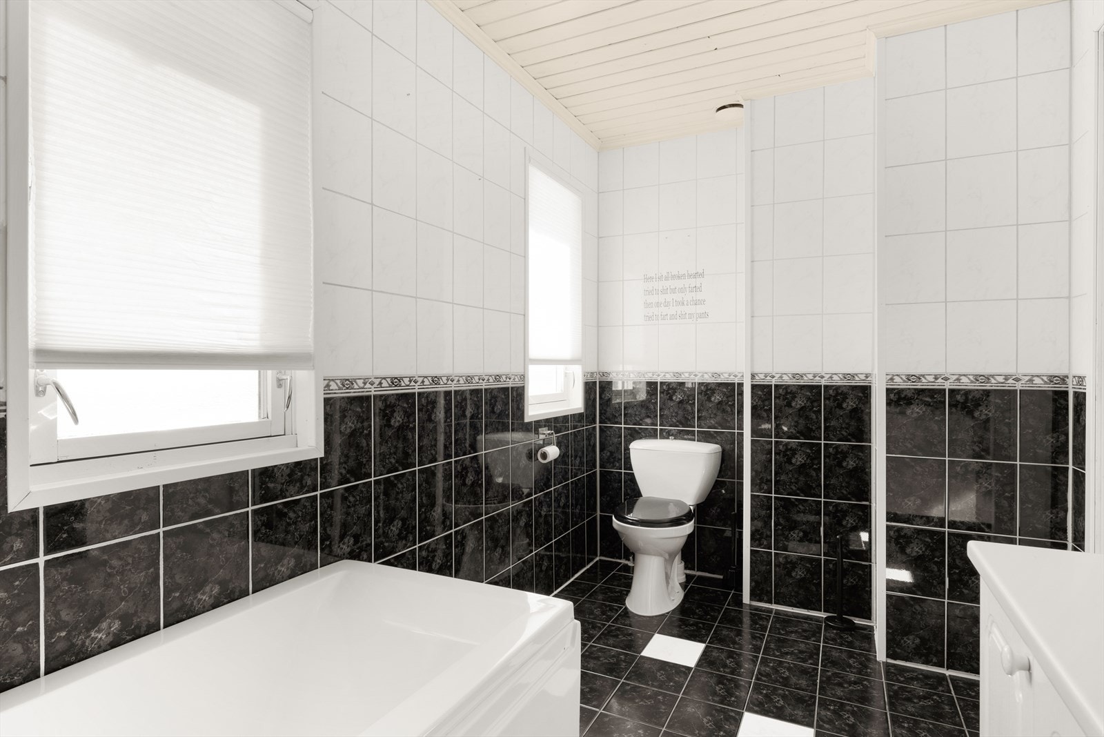 Bad med keramiske fliser på gulv, keramiske fliser på
vegger og malte plater i himling. Galleribilde