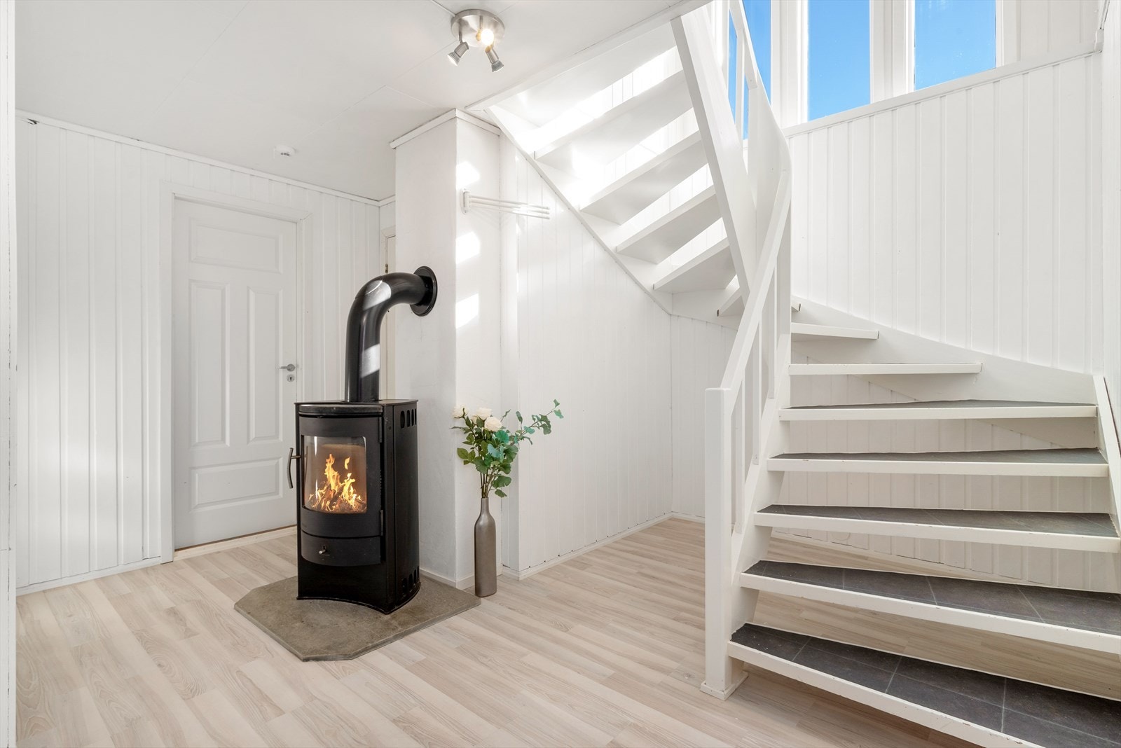Her finner vi en lys og flott gang med vedovn som sørger for gjennomgående varme i huset Galleribilde