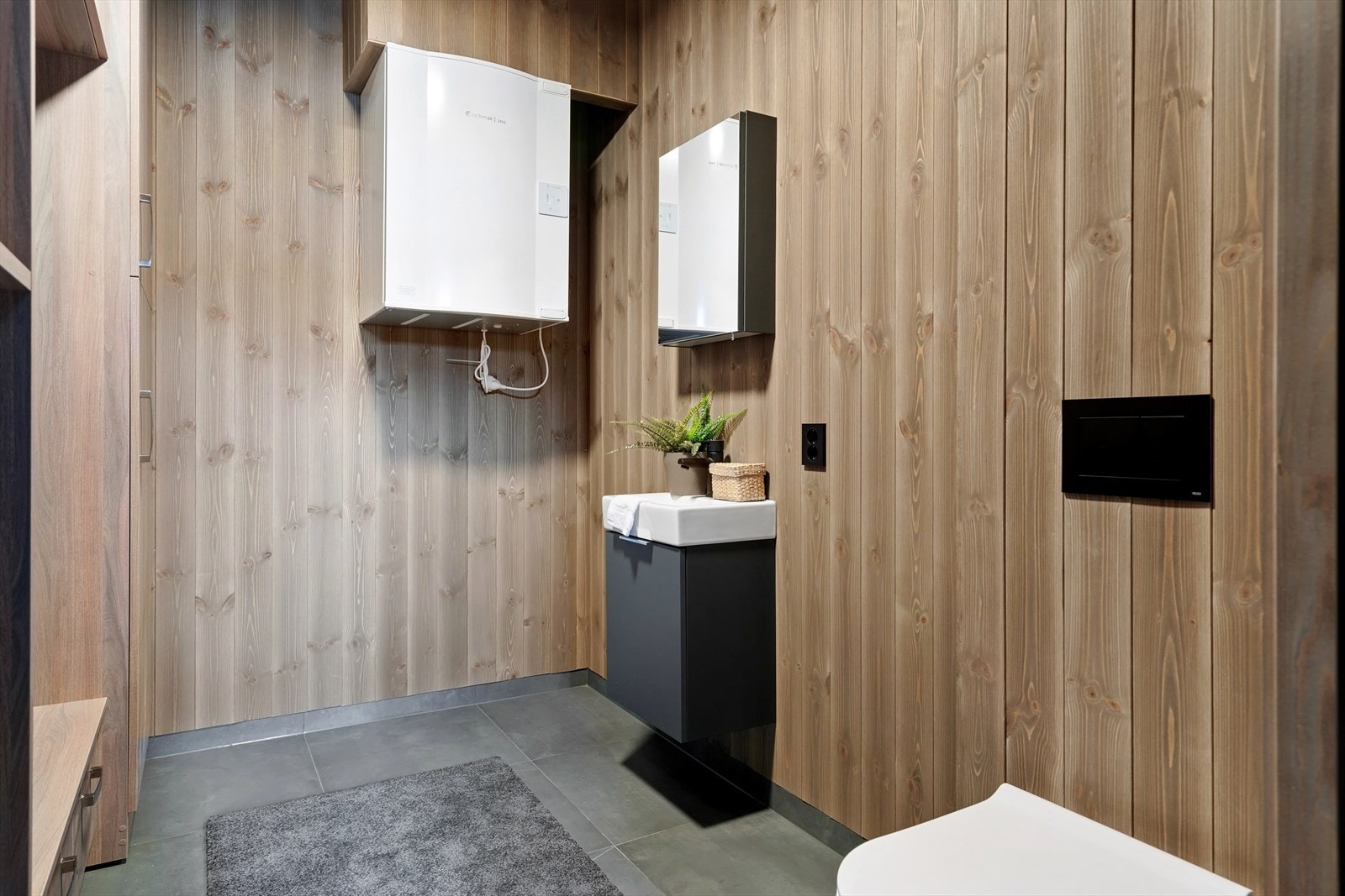 Vaskerommet er innredet med vask, vegghengt toalett, opplegg til vaskemaskin samt skap til oppbevaring. Varmtvannbereder (200 liter) er plassert i skap. Galleribilde