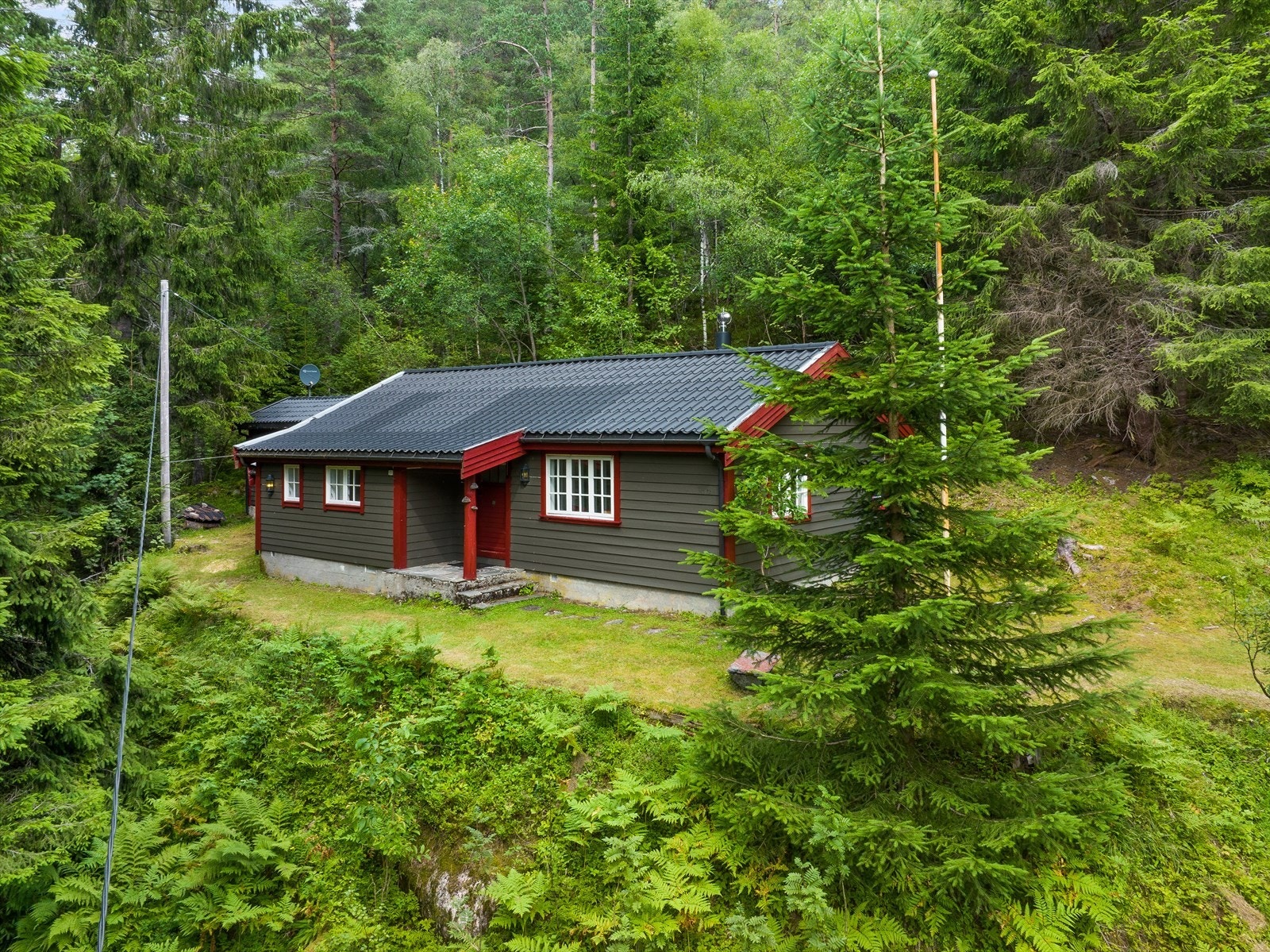 Hytten ligger på en flat tomt. Galleribilde
