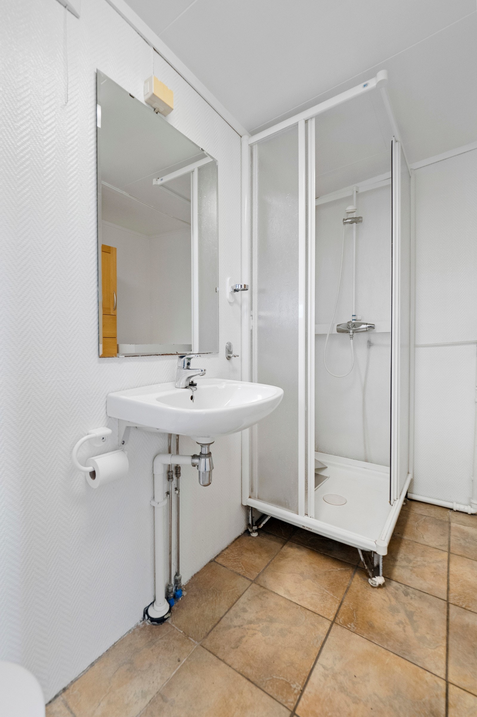 Badet er innredet med servant, toalett og dusjkabinett samt opplegg for vaskemaskin Galleribilde