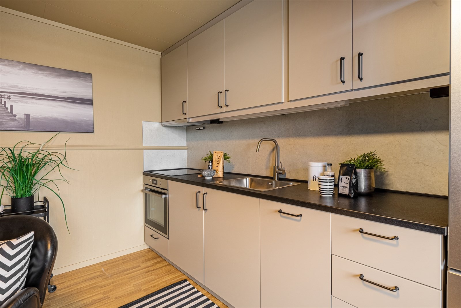 Det er laminat benkeplate med nedfelt kum og blandebatteri, samt integrerte hvitevarer som komfyr, platetopp og oppvaskmaskin. Galleribilde