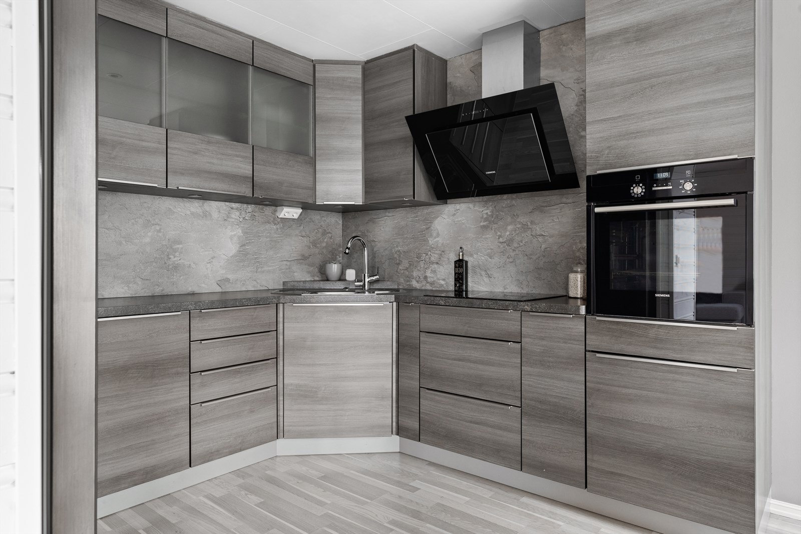 Kjøkkeninnredningen har en arbeidsvennlig hesteskoform med takhøye skap, mye skapplass og langstrukne arbeidsbenker. Galleribilde