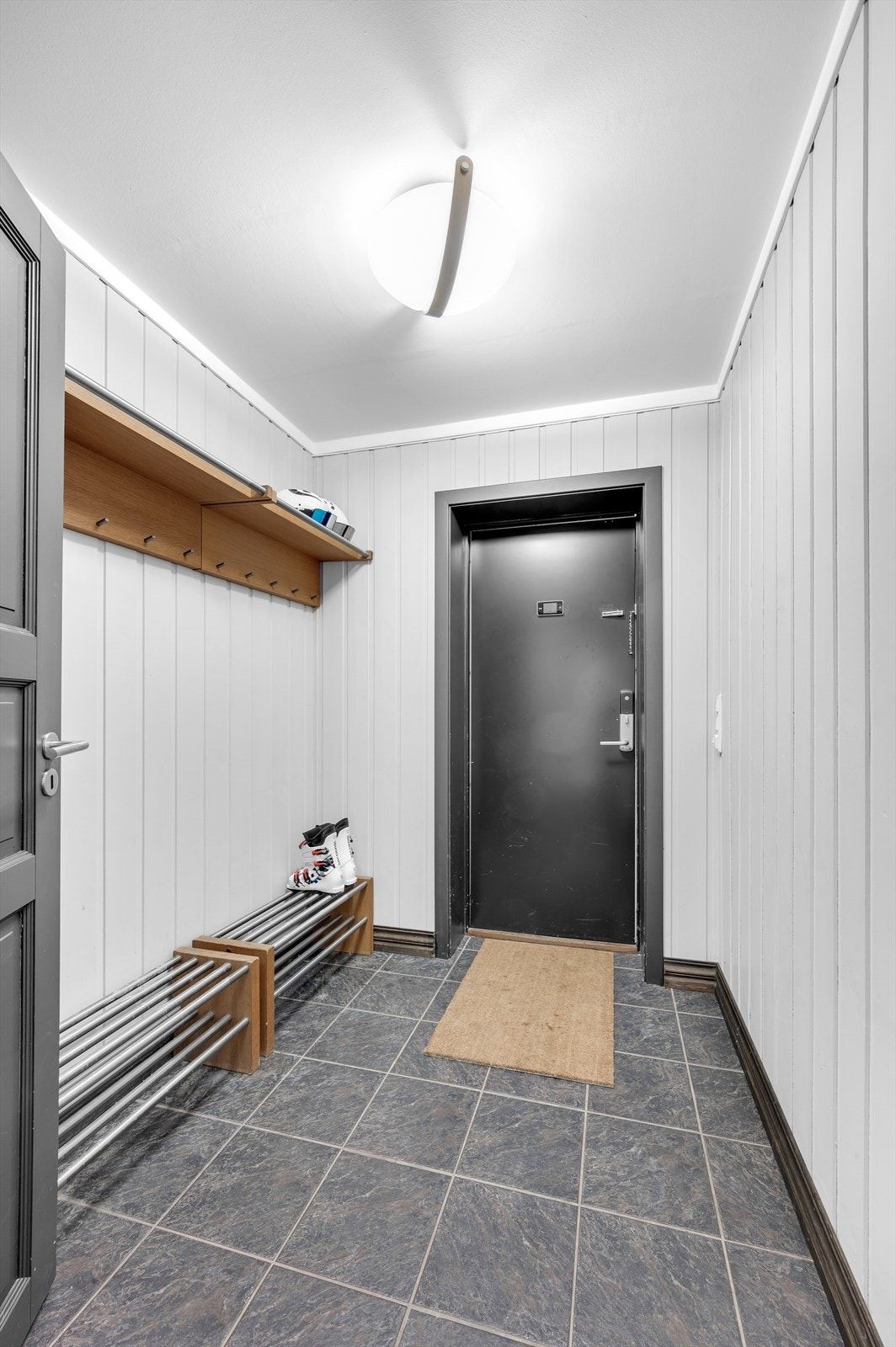 Flislagt gang med god plass til å henge skitøy Galleribilde