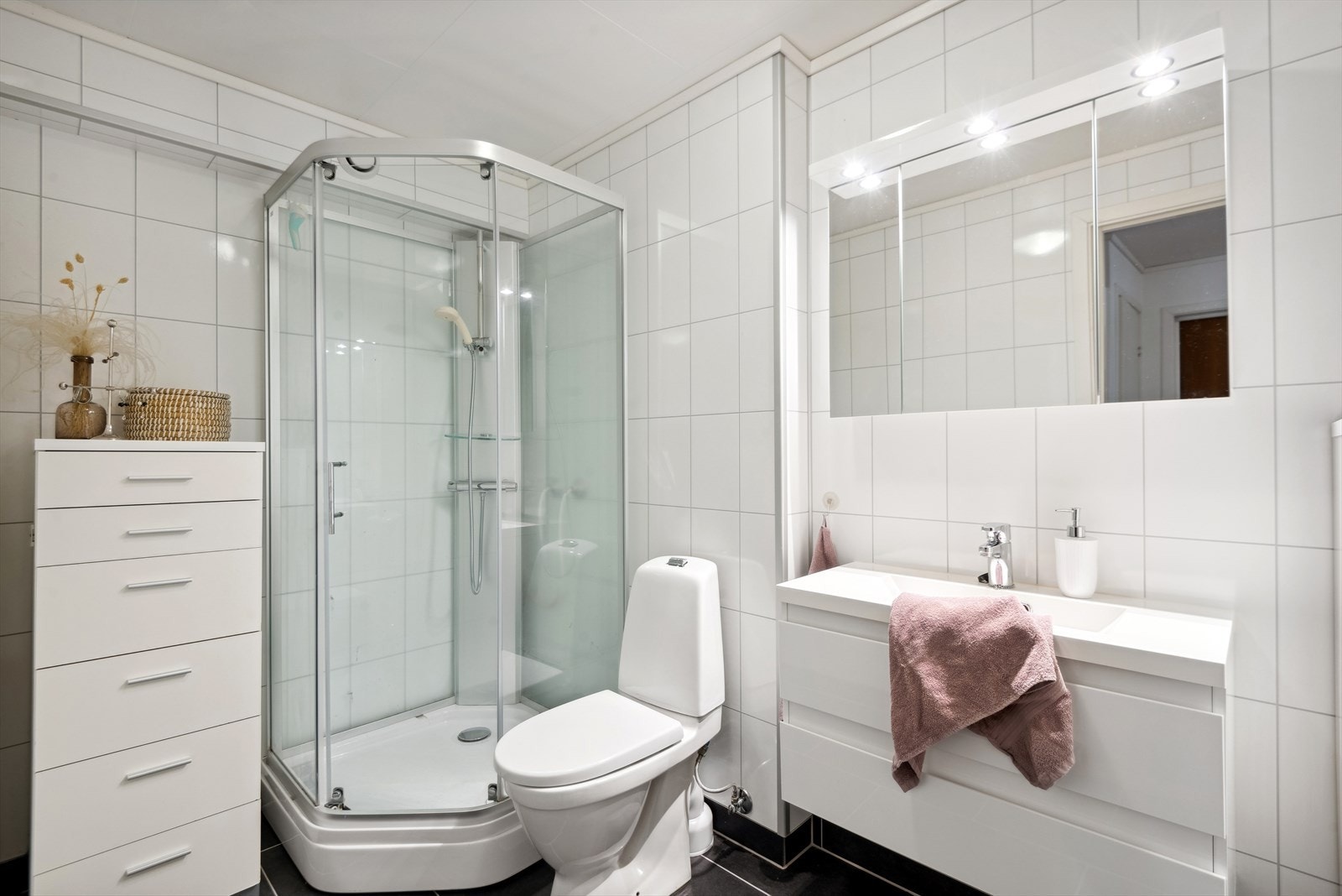 Badet er av god storleik. Det er utstyrt med servant i møbel, toalett og dusjkabinett. Galleribilde