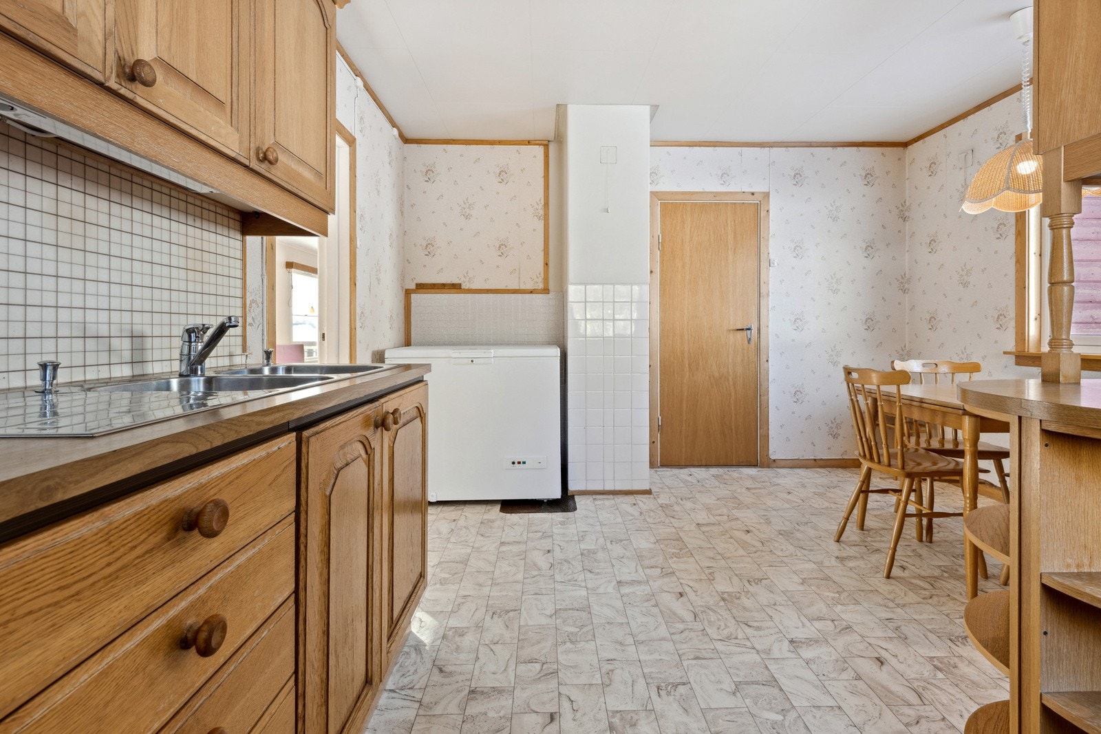 Kjøkkenet ligger i eget rom på enden av stuen, med innredning av profilerte eikefronter og laminat benkeplate. Galleribilde