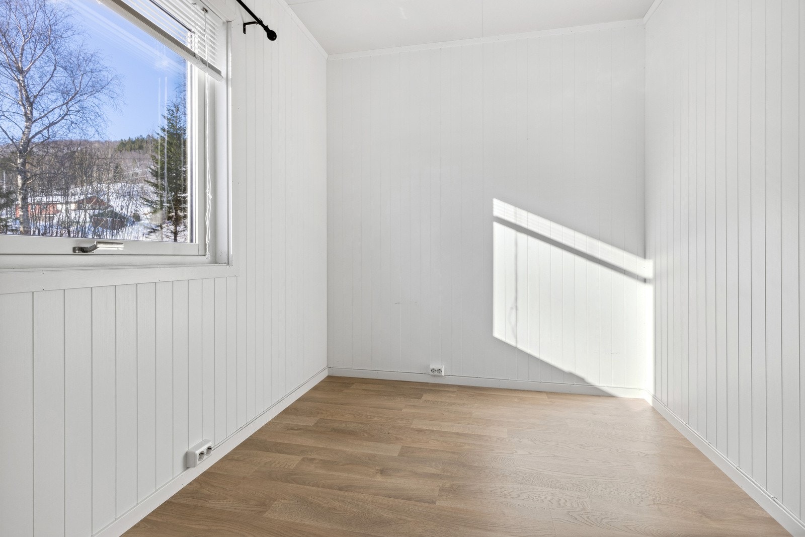 Det første soverommet ligger i 1. etasje, og fremstår moderne med lysmalte vegger. Galleribilde